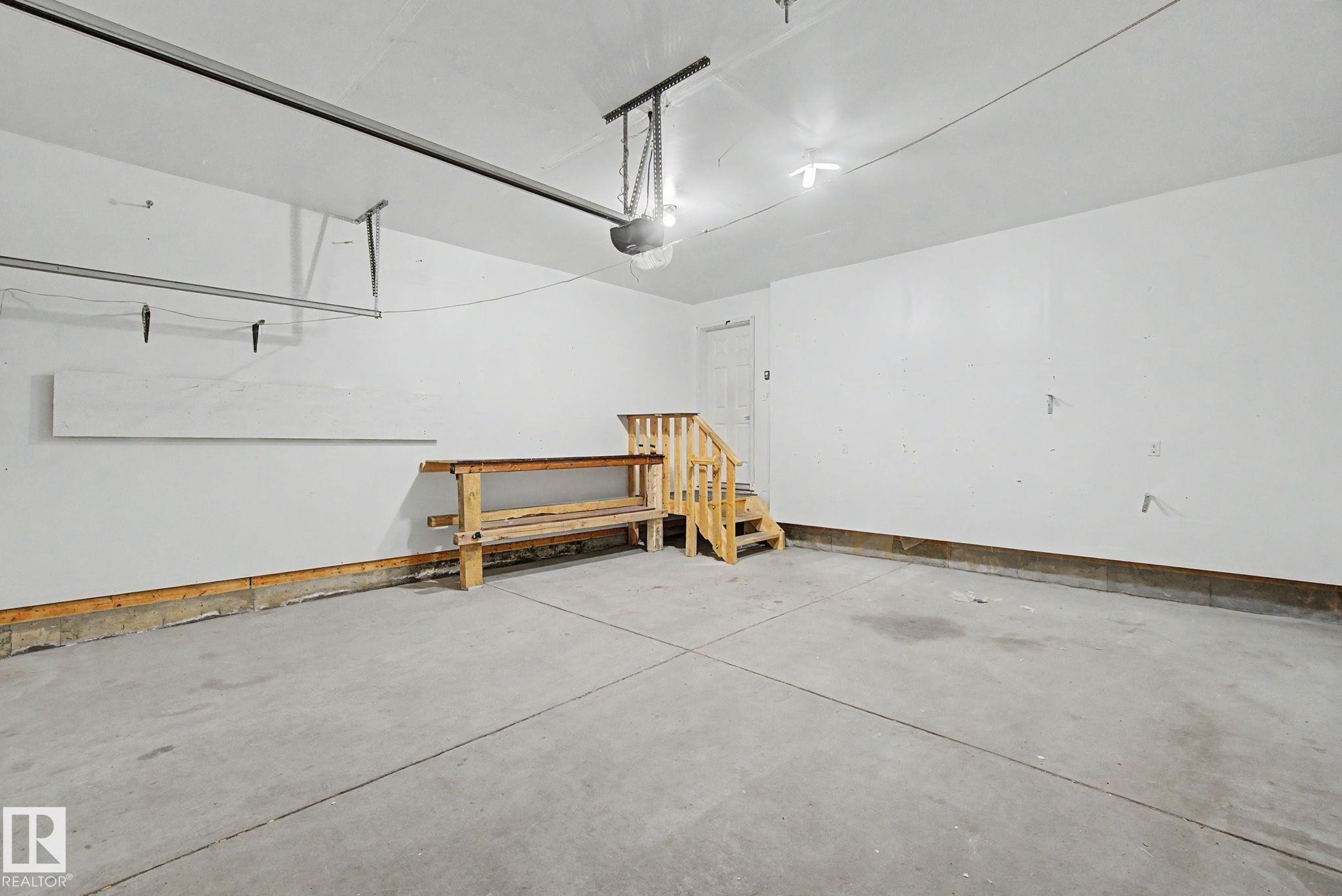 Spacious garage featuring a concrete floor, bright white walls, and a convenient interior access door - 315 Watt Boulevard Sw, Edmonton, AB - Indoor Photo Showing Garage