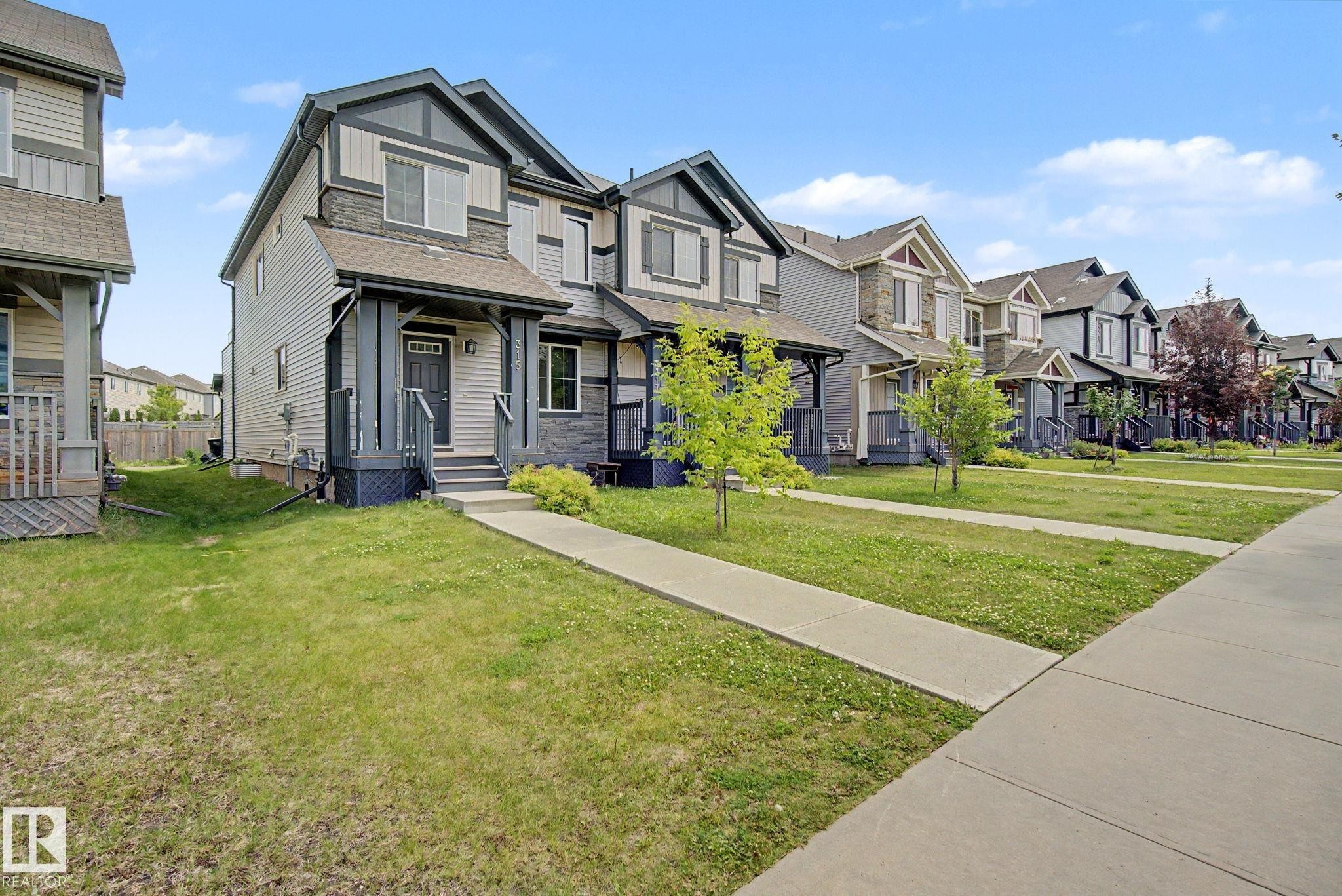 Contemporary townhouse featuring a multi-tone facade with siding and stone accents - 315 Watt Boulevard Sw, Edmonton, AB - Outdoor With Facade