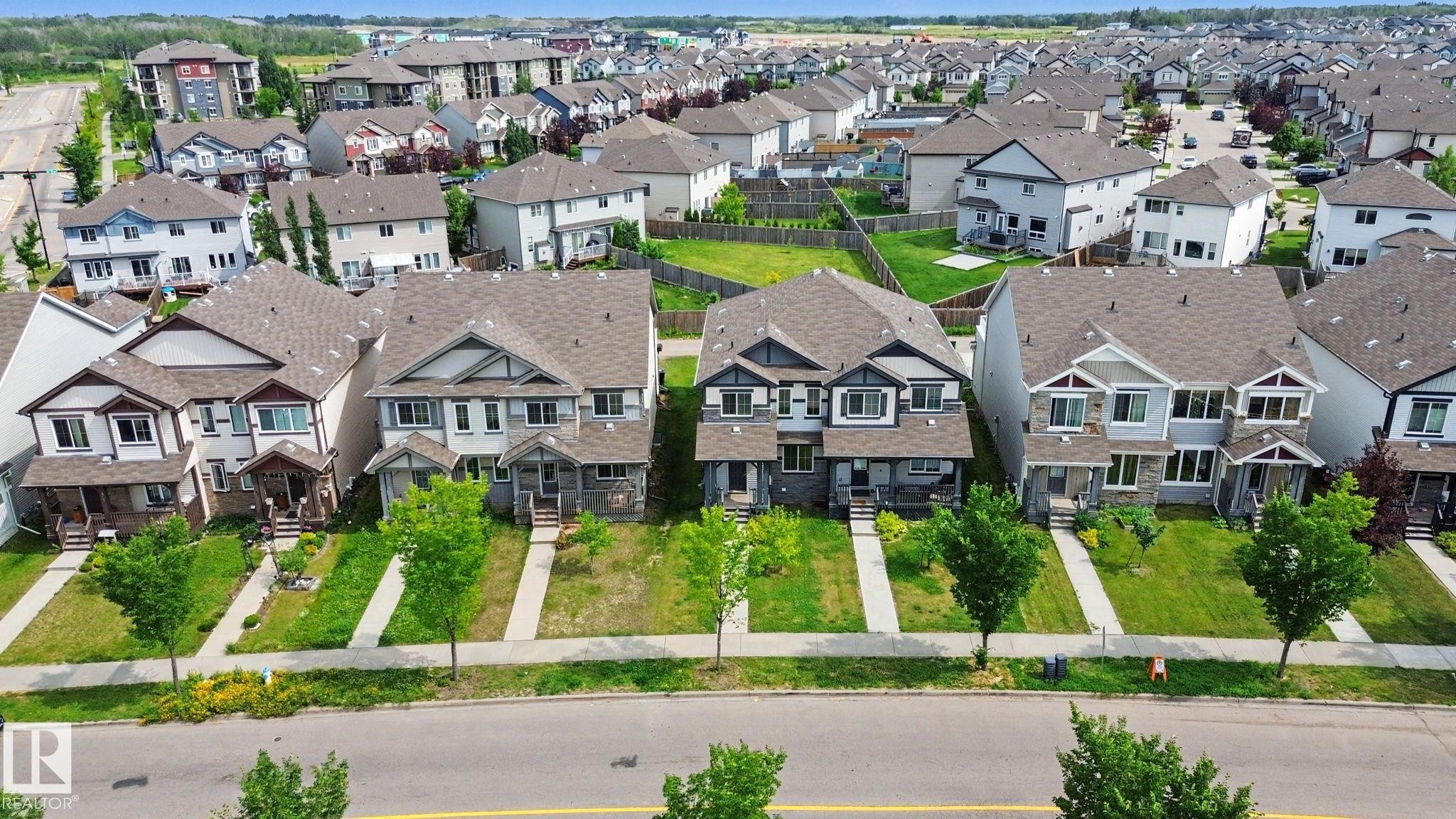 Row of residential properties featuring varied architectural styles and asphalt shingle roofs - 315 Watt Boulevard Sw, Edmonton, AB - Outdoor With Facade