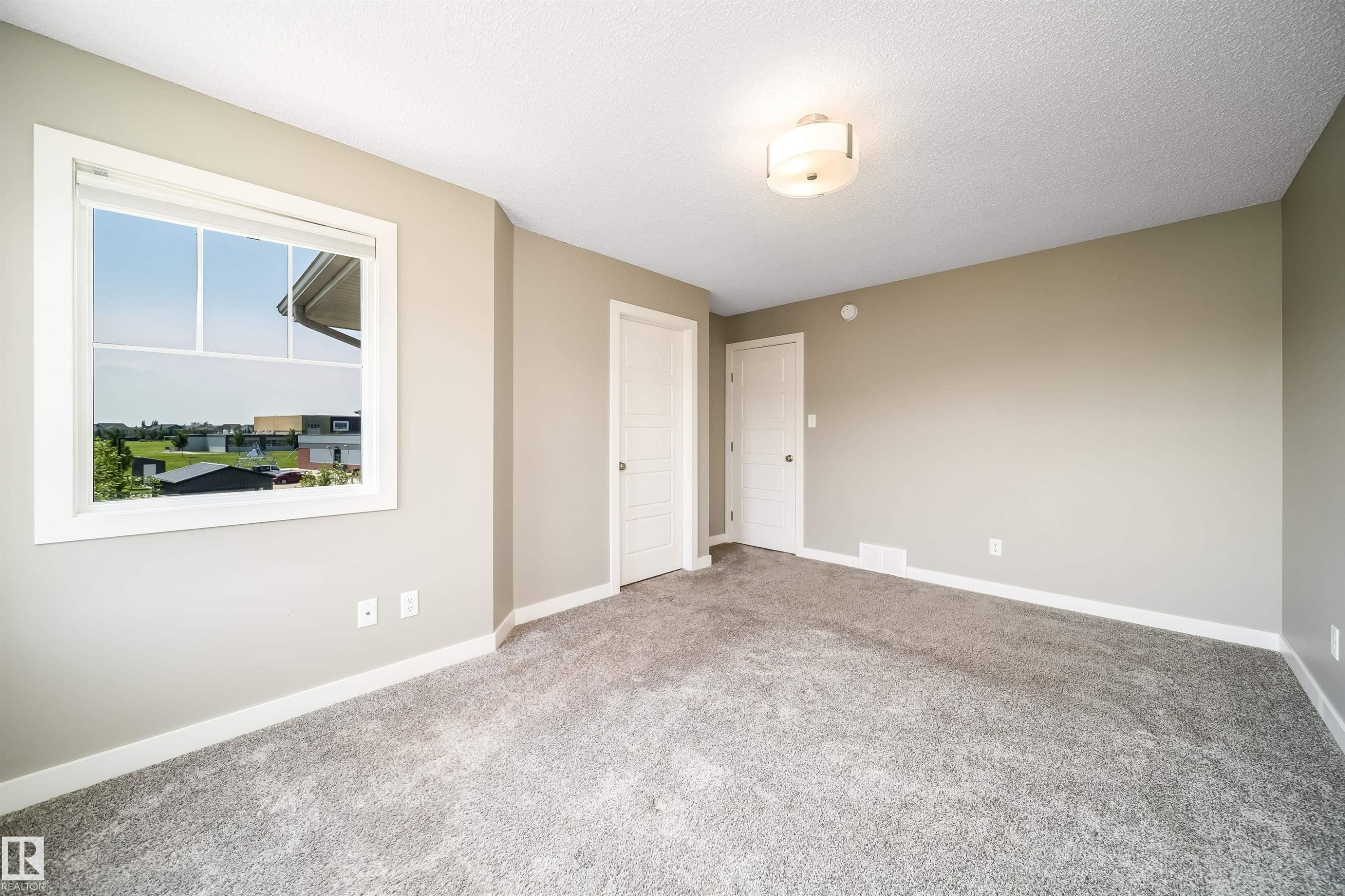 Neutral-toned interior room featuring light gray walls, plush gray carpeting, and white trim - 114 James Crescent, St. Albert, AB - Indoor Photo Showing Other Room