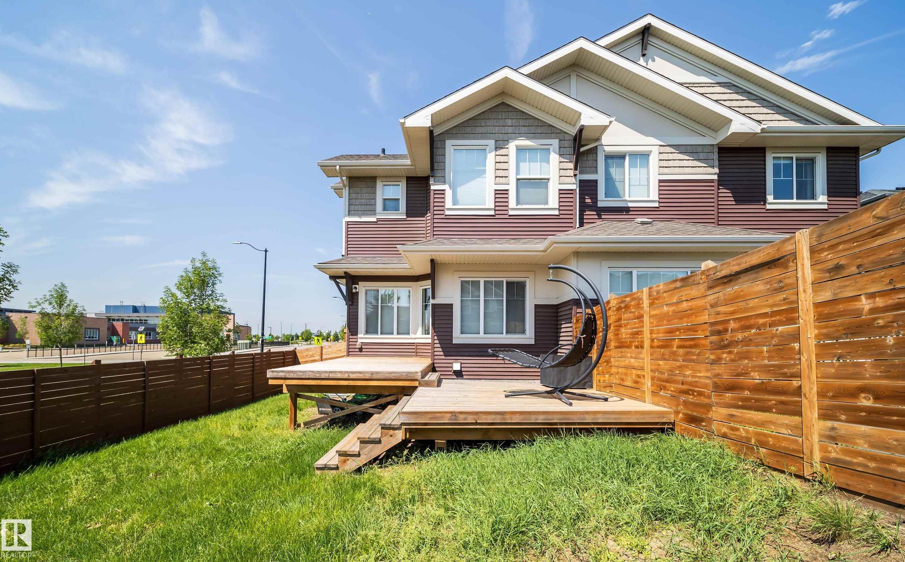 Rear exterior featuring a multi-level wood deck with stairs, a private wood fence, and a green lawn - 114 James Crescent, St. Albert, AB - Outdoor With Deck Patio Veranda