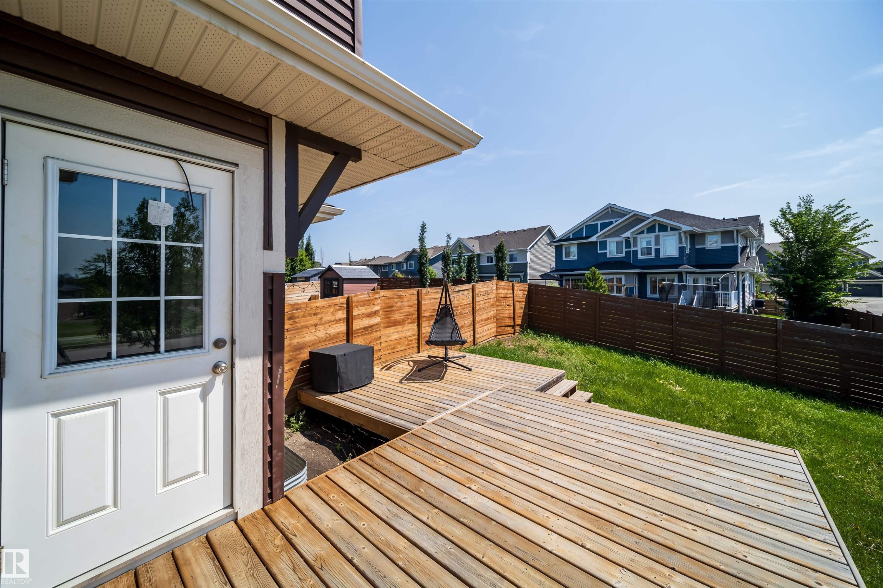 Expansive multi-level wood deck featuring a built-in privacy fence, direct access door, and a grassy yard - 114 James Crescent, St. Albert, AB - Outdoor With Deck Patio Veranda With Exterior