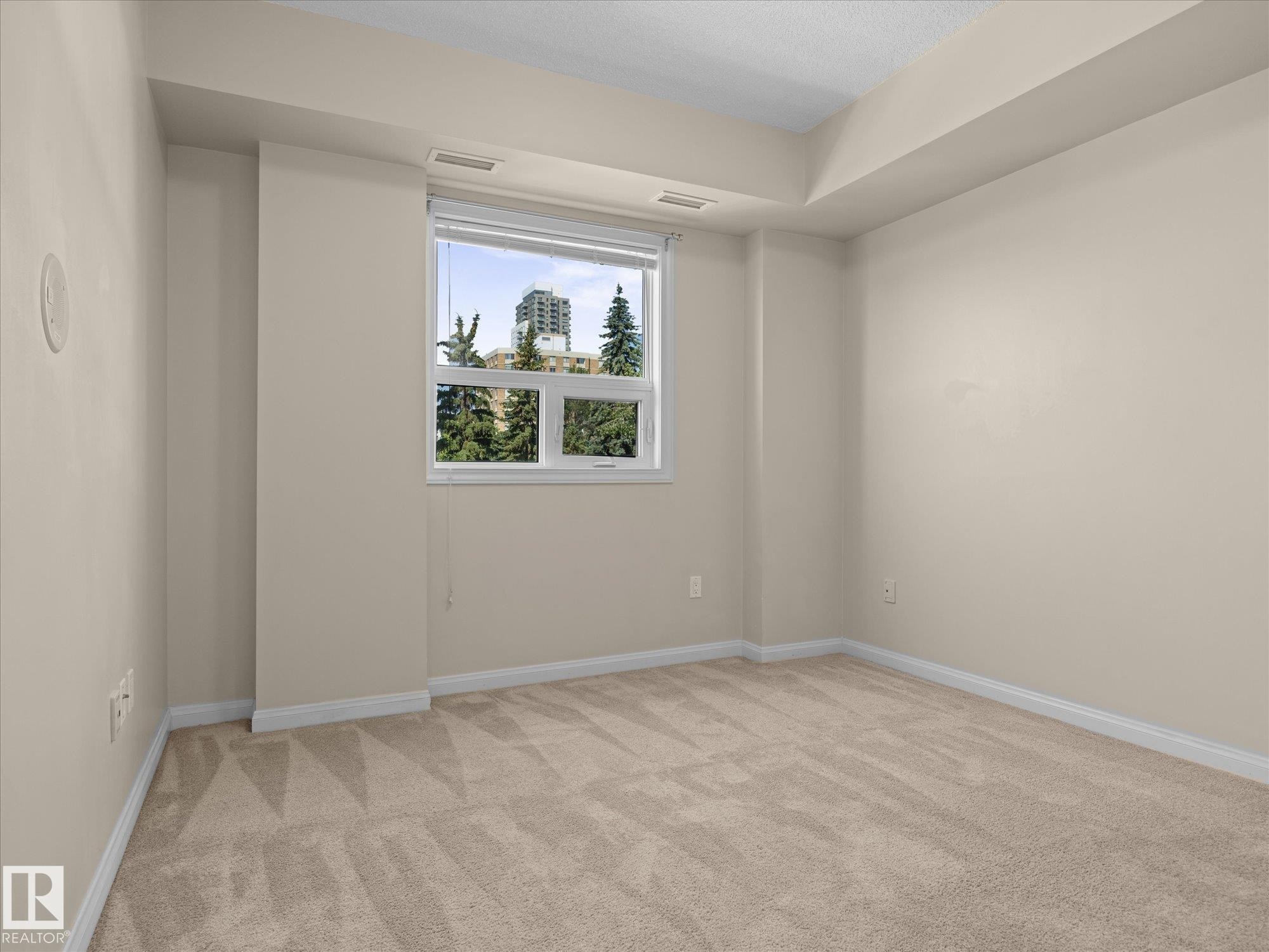 Carpeted room with a white-framed window - #707 9819 104 St Nw, Edmonton, AB