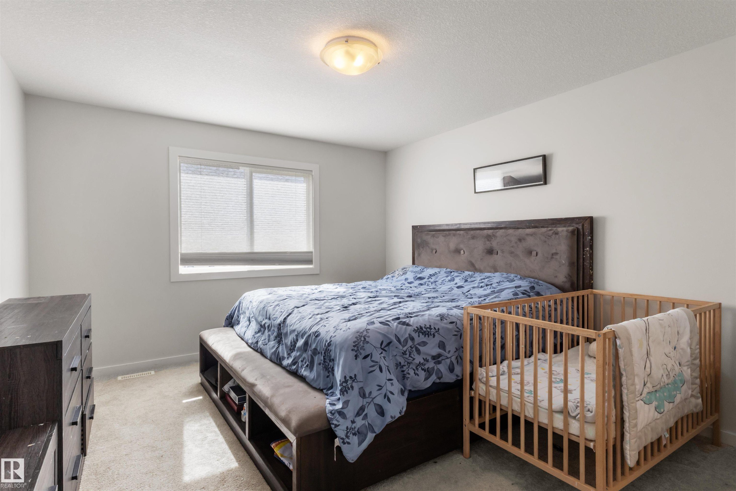 Bedroom featuring light gray walls, white trim, and light-colored carpet flooring - 1471 Plum Circle Sw, Edmonton, AB - Indoor Photo Showing Bedroom