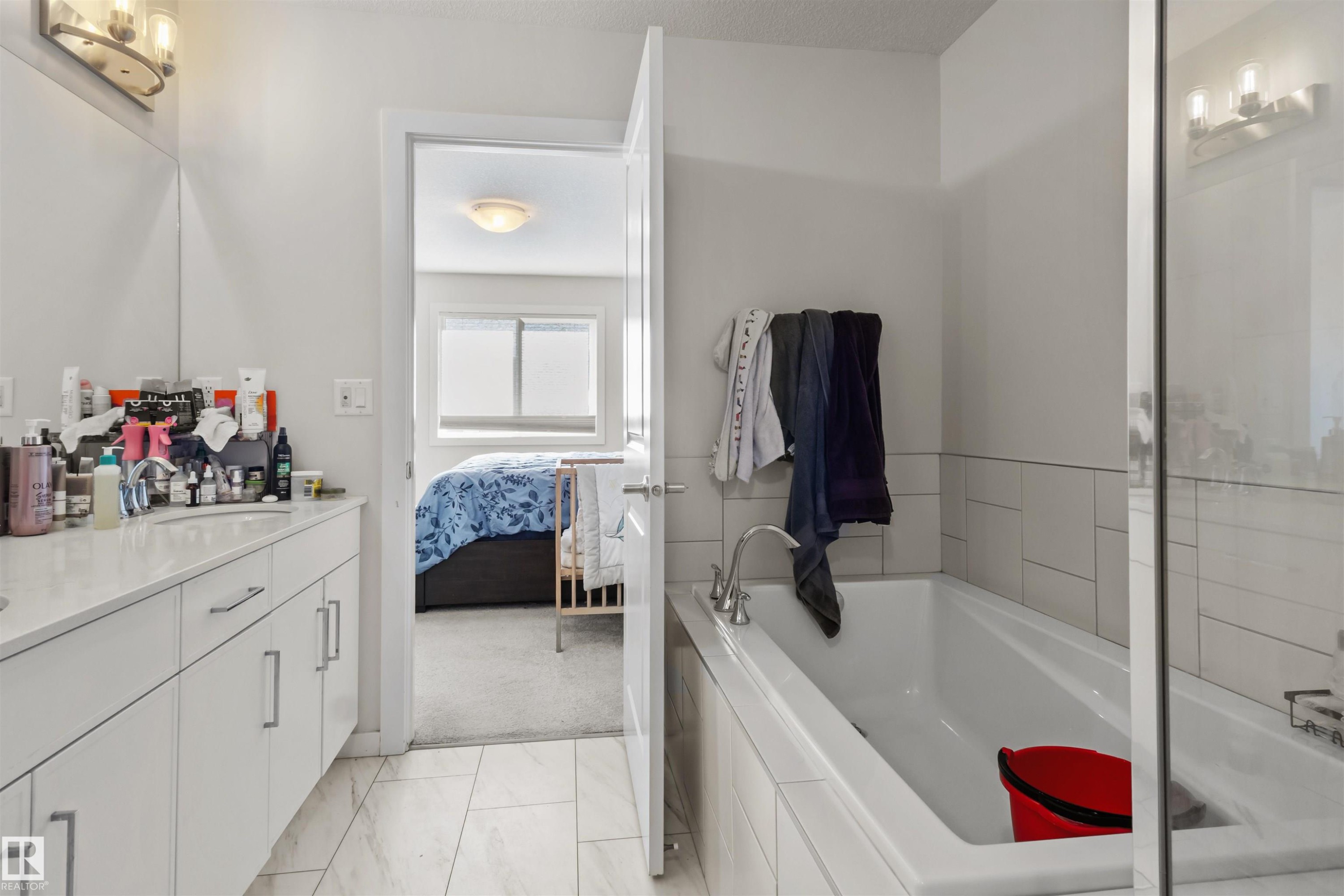 Bathroom featuring a white vanity with integrated sink, chrome faucet, and overhead three-bulb vanity light - 1471 Plum Circle Sw, Edmonton, AB - Indoor Photo Showing Bathroom