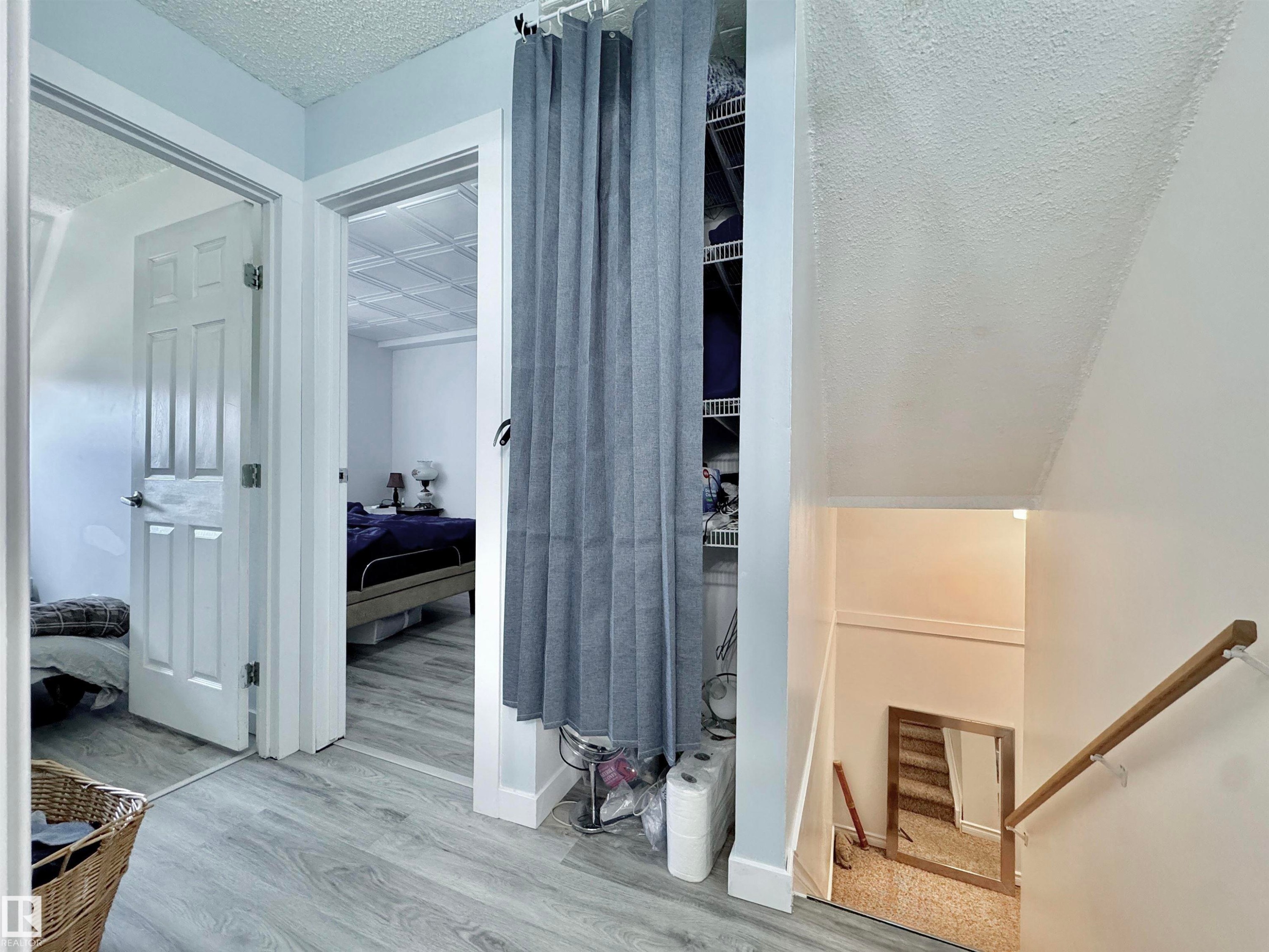 Light wood-finish flooring throughout the hallway and into the visible room - #29 13580 38 St Nw, Edmonton, AB - Indoor Photo Showing Other Room