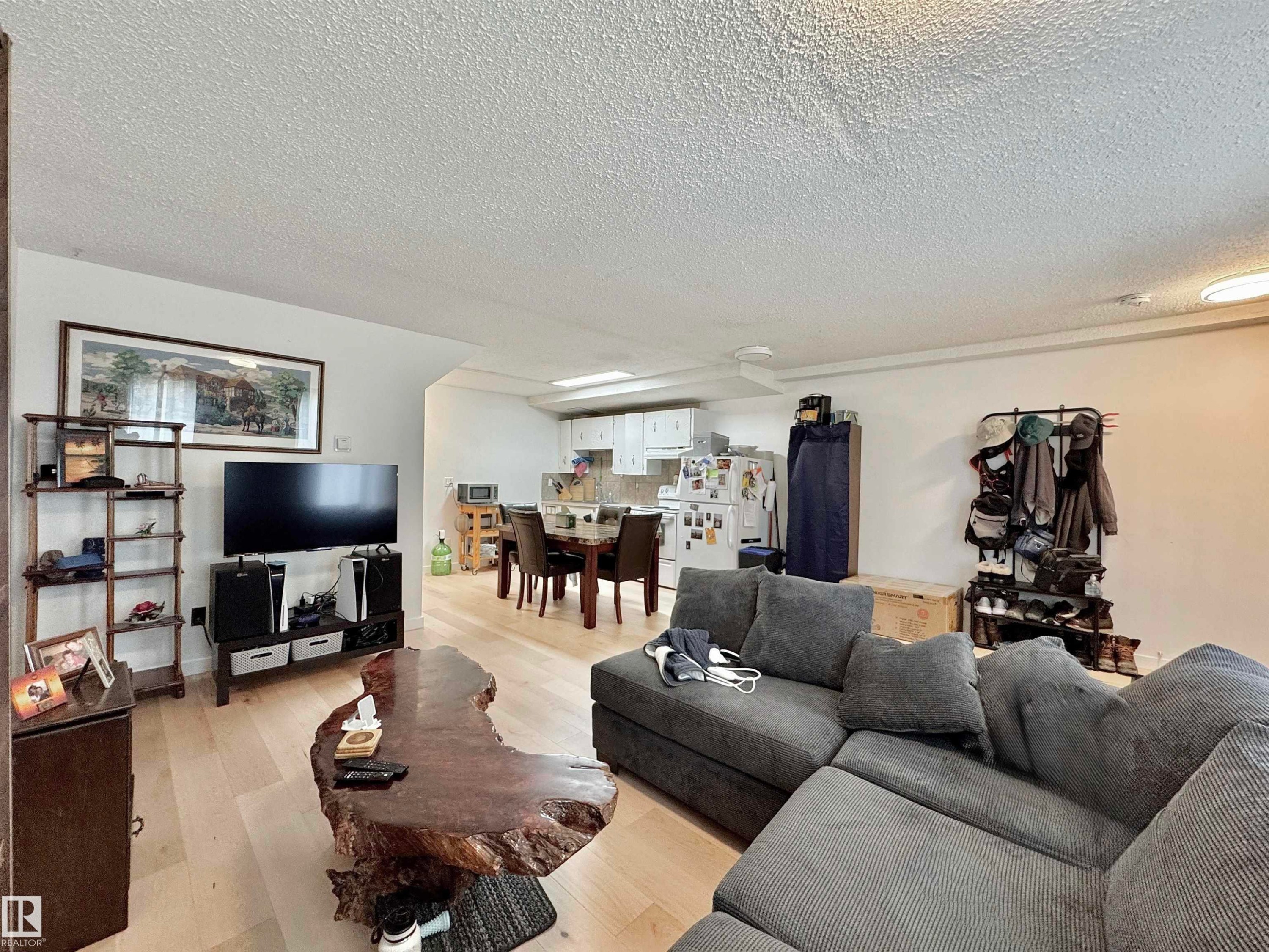 Spacious living area featuring light wood-finish flooring, a contemporary ceiling, and ample wall space - #29 13580 38 St Nw, Edmonton, AB - Indoor Photo Showing Living Room