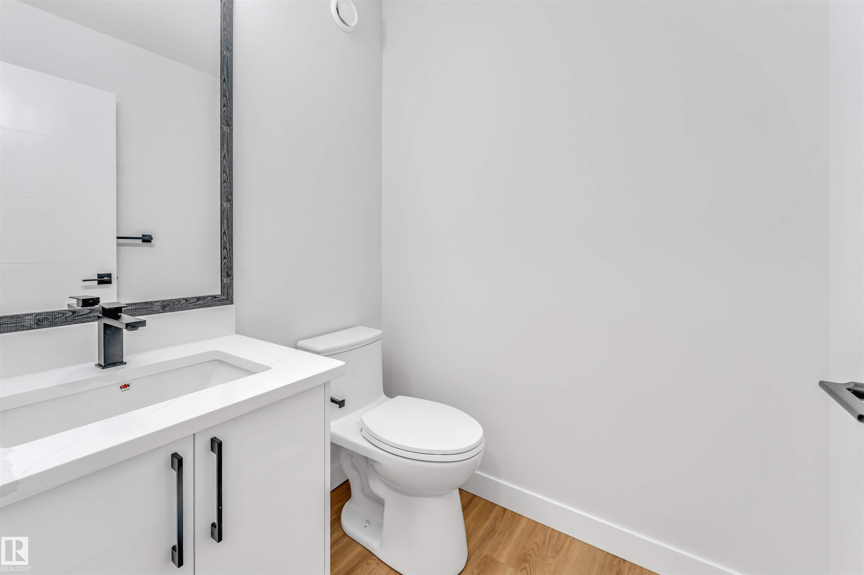 White vanity with integrated sink, black faucet, and coordinating black hardware - 1712 27 St Nw, Edmonton, AB - Indoor Photo Showing Bathroom