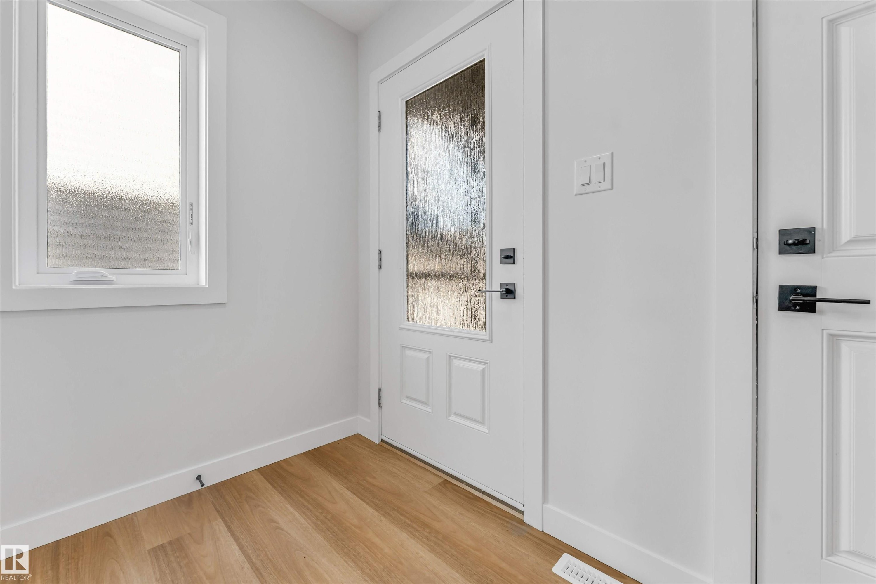Entryway featuring light wood-finish flooring, white trim, and a window with privacy glass - 1714 27 St. Nw, Edmonton, AB - Indoor Photo Showing Other Room