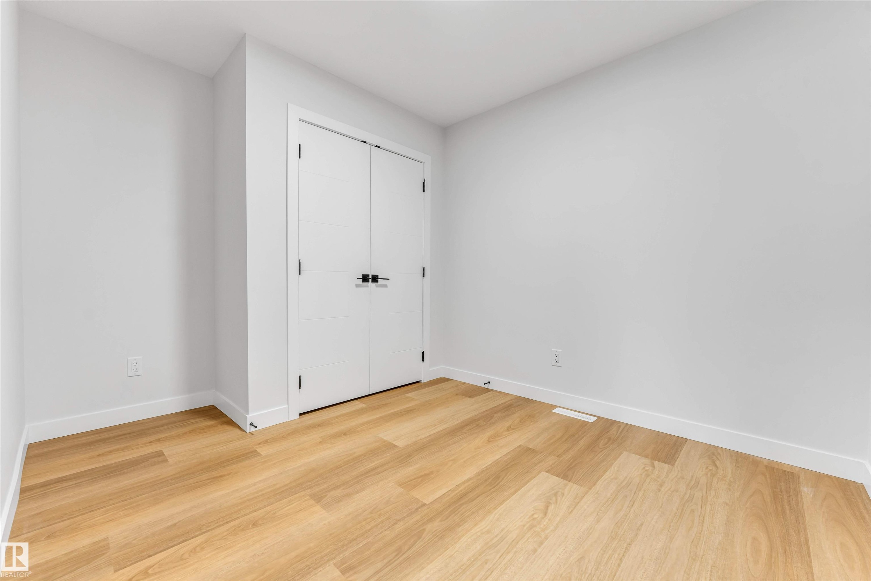 Neutral wall finishes with wood-finish flooring and white baseboards - 1714 27 St. Nw, Edmonton, AB - Indoor Photo Showing Other Room