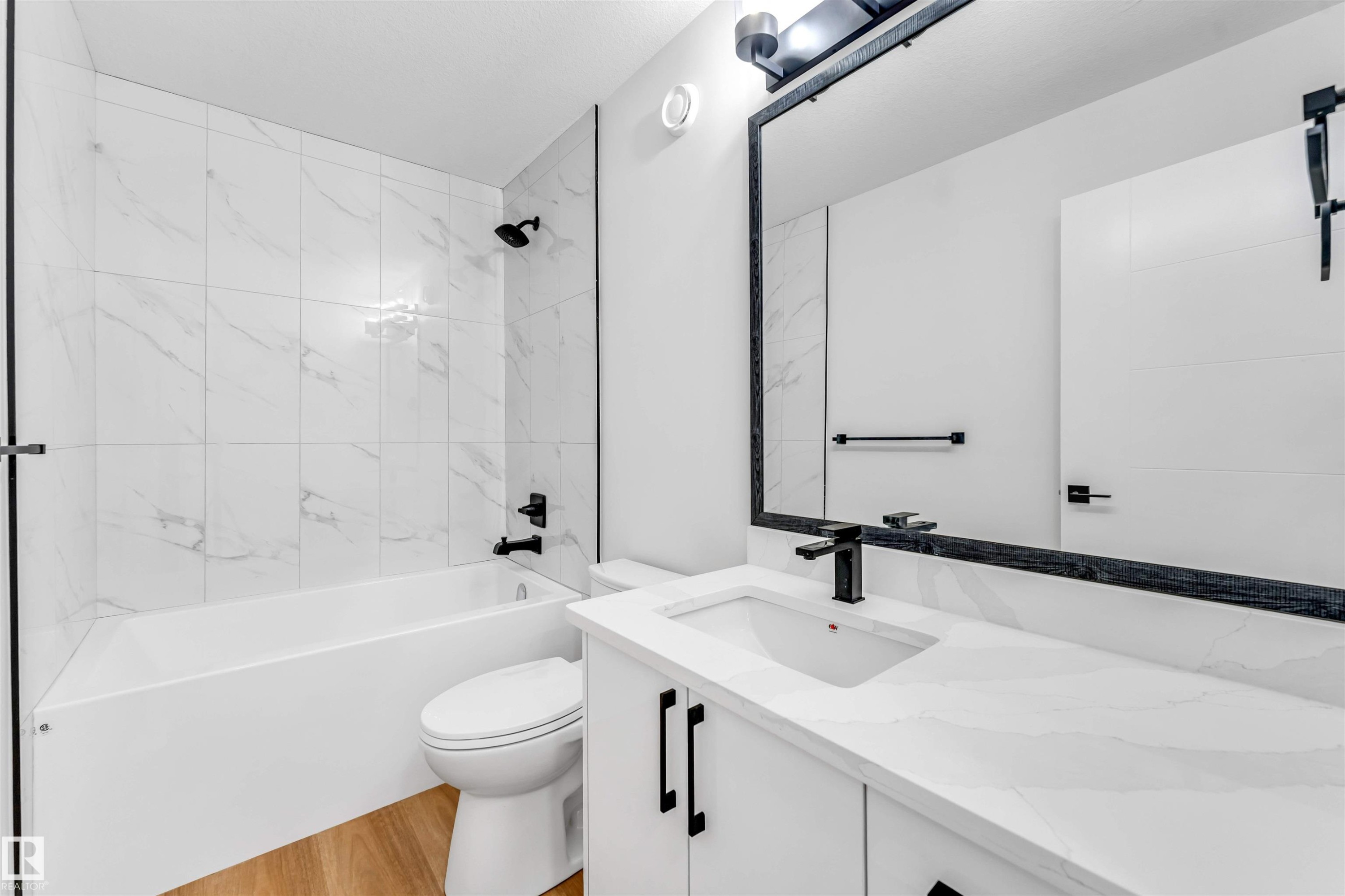 Bathroom featuring a white vanity with a rectangular sink, a white countertop, and matte black fixtures - 1714 27 St. Nw, Edmonton, AB - Indoor Photo Showing Bathroom