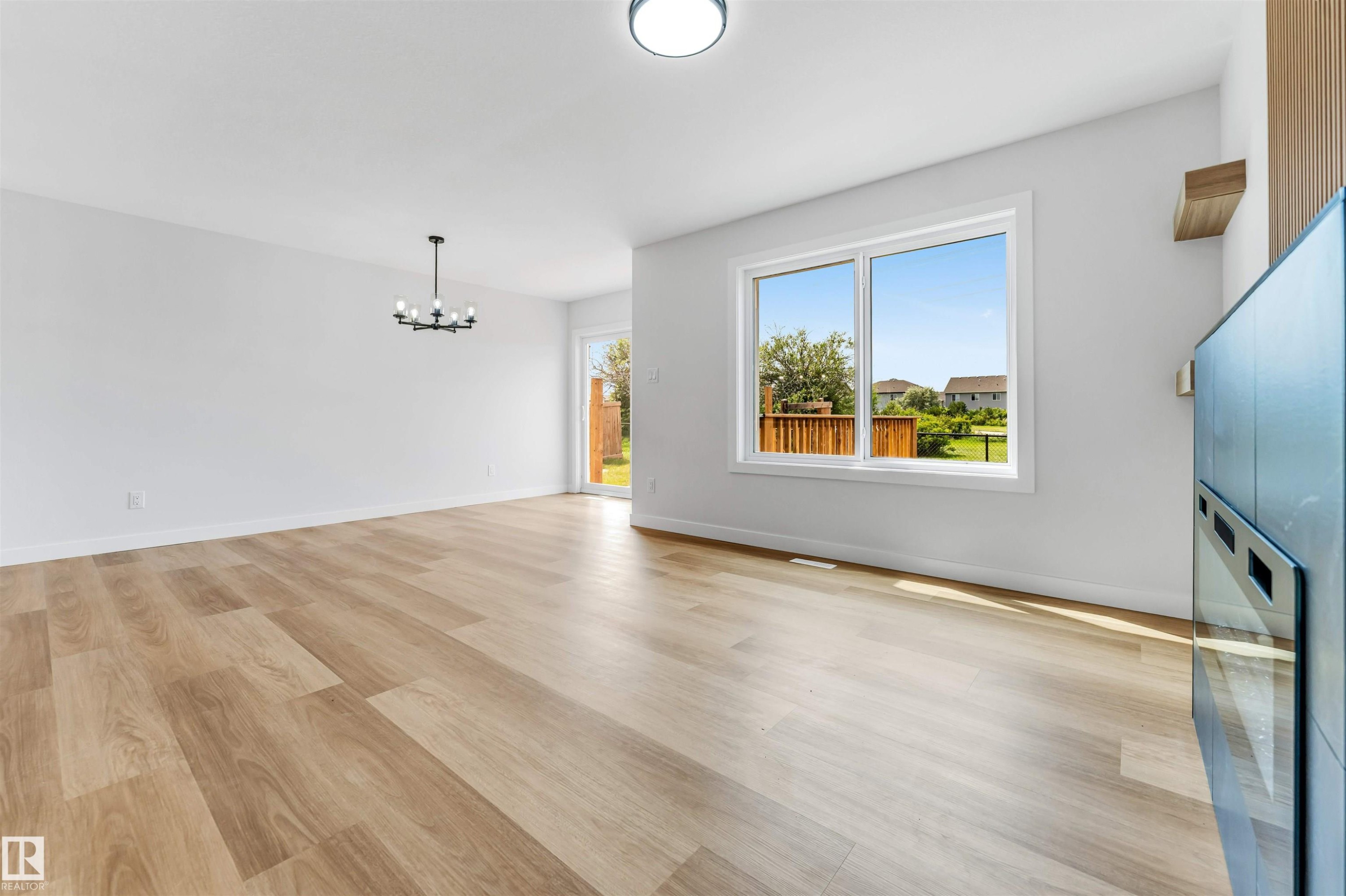 Open-concept living space with light wood-finish flooring - 1714 27 St. Nw, Edmonton, AB - Indoor