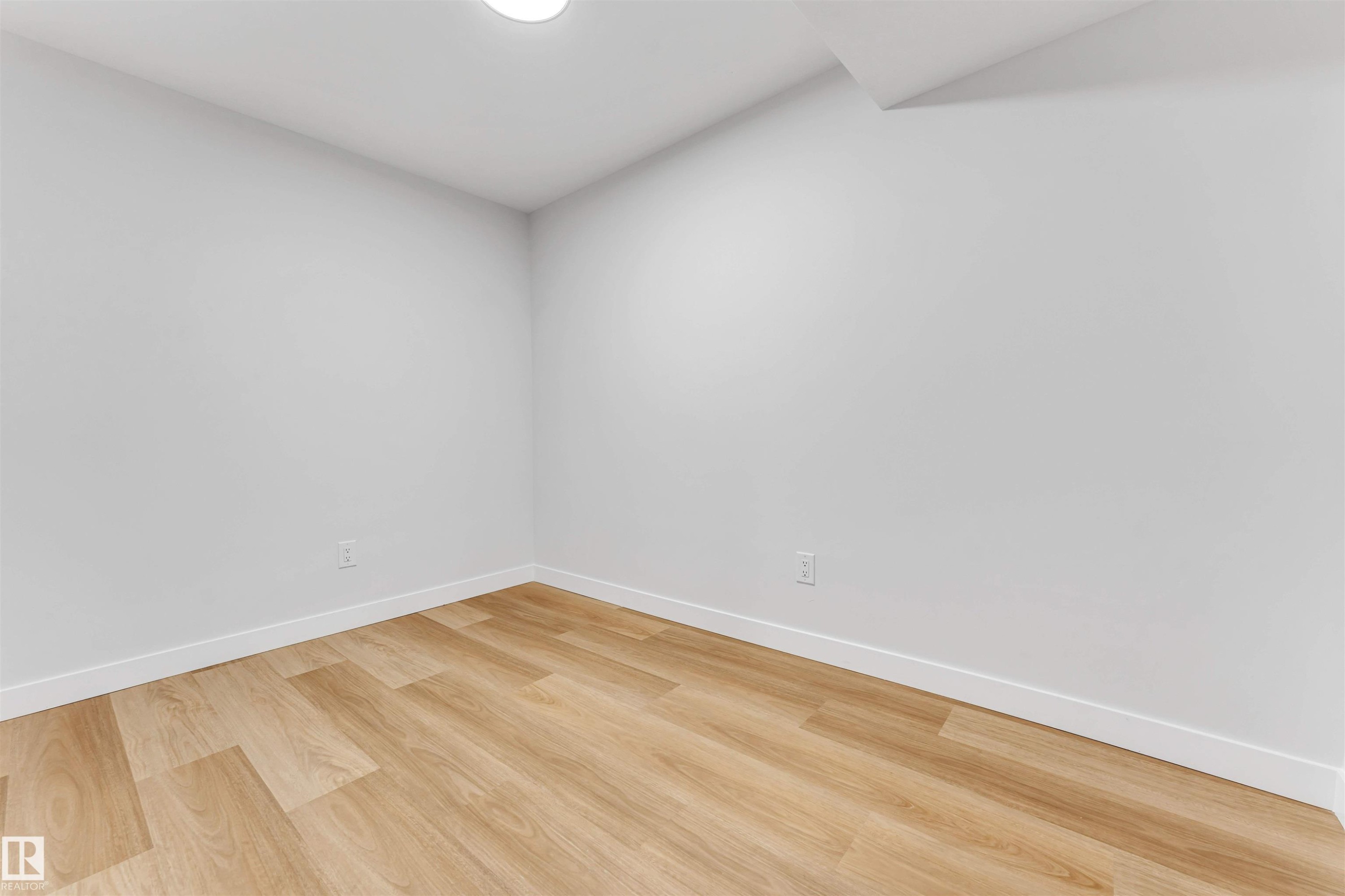 Interior room with light wood-finish flooring, white baseboards, and neutral wall tones - 1714 27 St. Nw, Edmonton, AB - Indoor Photo Showing Other Room