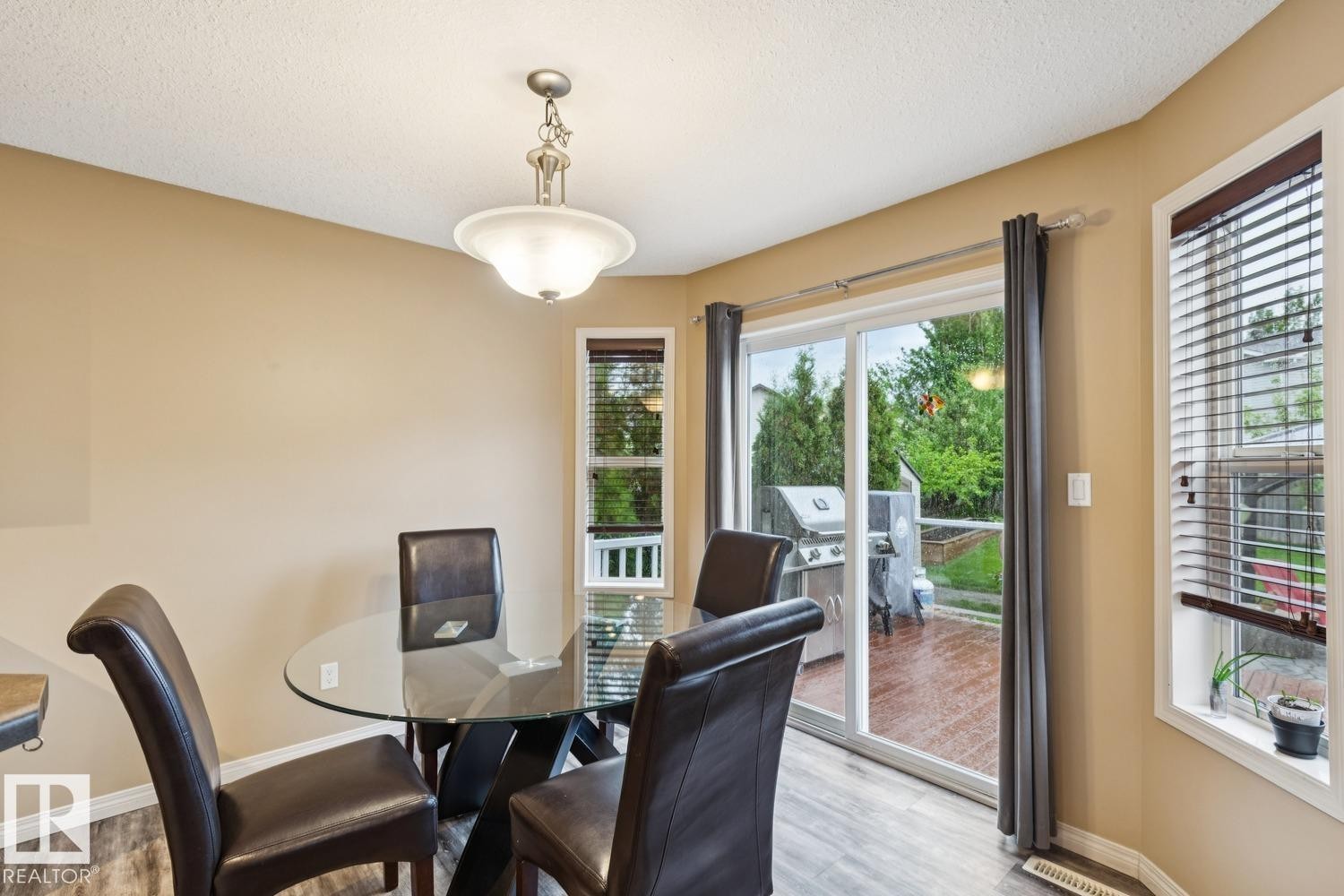 Dining area featuring wood-finish flooring and a pendant light fixture - 16765 119 Street Nw, Edmonton, AB - Indoor Photo Showing Dining Room