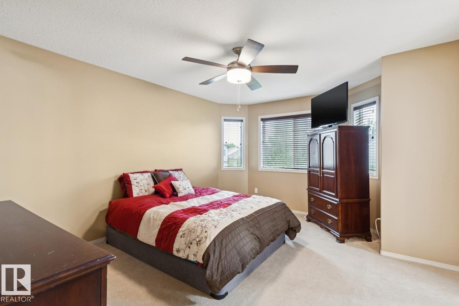 Comfortable bedroom featuring neutral-toned walls, plush carpeting, and a ceiling fan with integrated lighting - 16765 119 Street Nw, Edmonton, AB - Indoor Photo Showing Bedroom