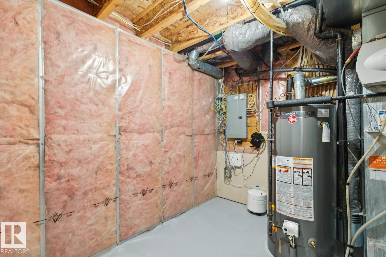 Utility room featuring a water heater, electrical panel, exposed ductwork, insulated walls, and a painted concrete floor - 16765 119 Street Nw, Edmonton, AB - Indoor Photo Showing Basement