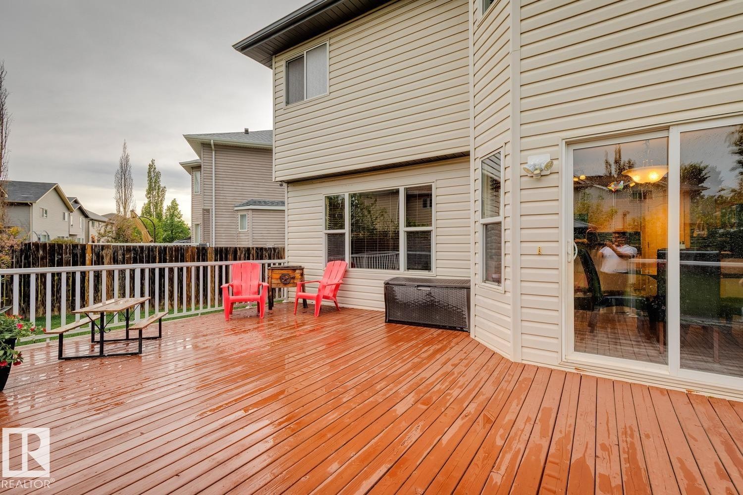 Spacious outdoor deck featuring wood-finish flooring, white railing, and sliding glass door access to the interior - 16765 119 Street Nw, Edmonton, AB - Outdoor With Deck Patio Veranda With Exterior