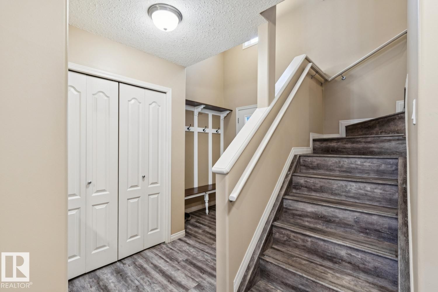 Entryway featuring wood-finish flooring and a staircase with white railings - 16765 119 Street Nw, Edmonton, AB - Indoor Photo Showing Other Room