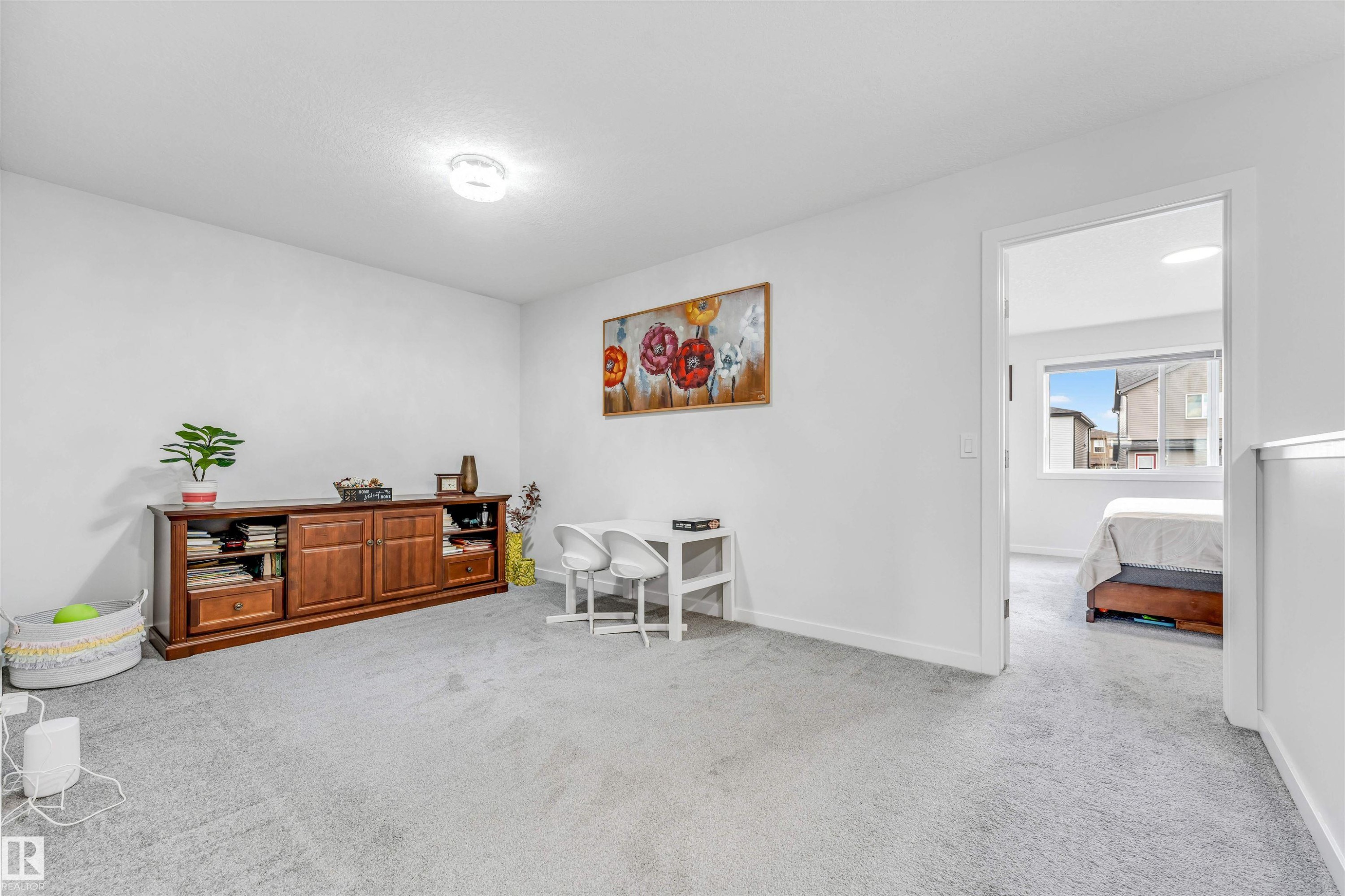 Expansive carpeted room featuring white walls and a contemporary flush-mount ceiling light - 425 41 Street, Edmonton, AB - Indoor