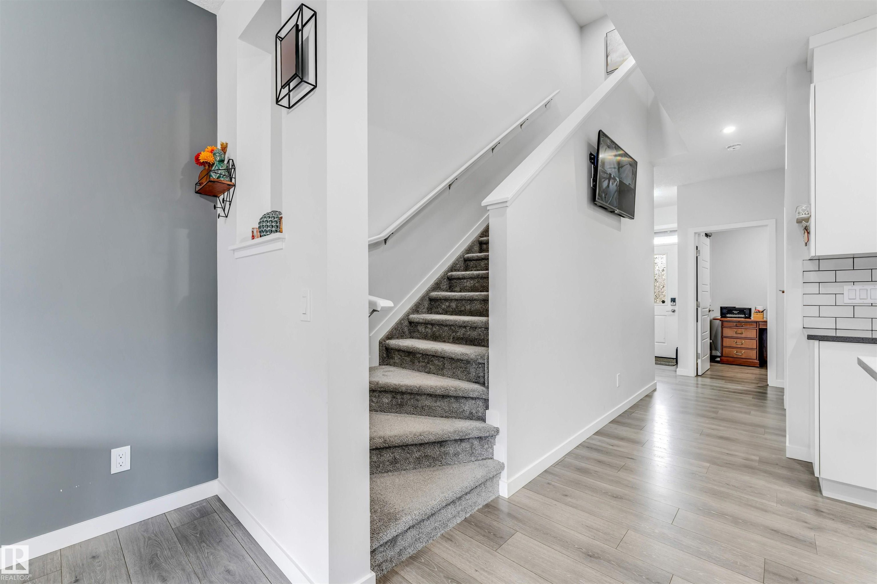 Carpeted staircase with white railing, wood-finish flooring, and white baseboards - 425 41 Street, Edmonton, AB - Indoor Photo Showing Other Room