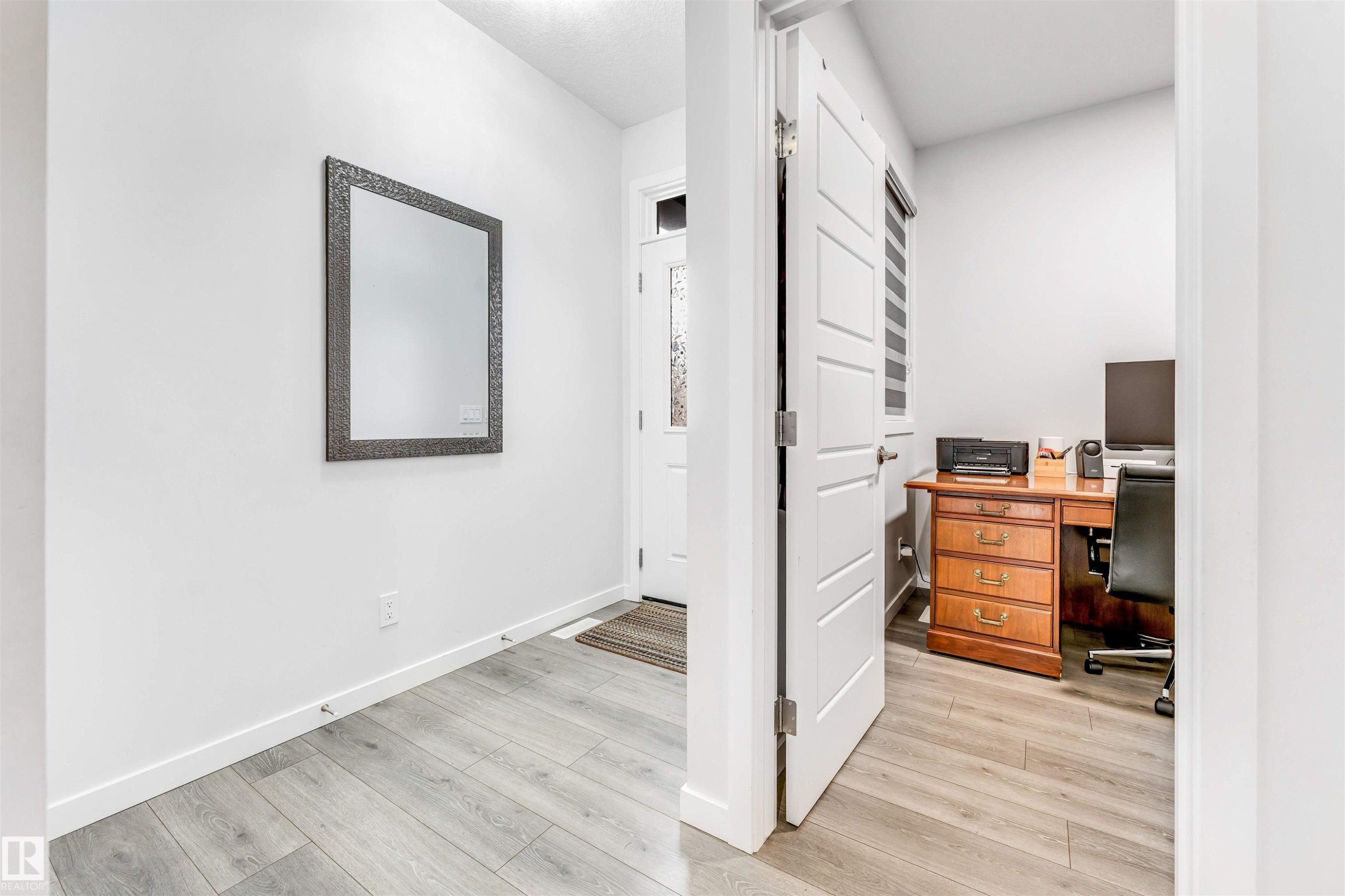 Entryway featuring light wood-finish flooring, white baseboards, and a front door with frosted glass detailing - 425 41 Street, Edmonton, AB - Indoor Photo Showing Other Room