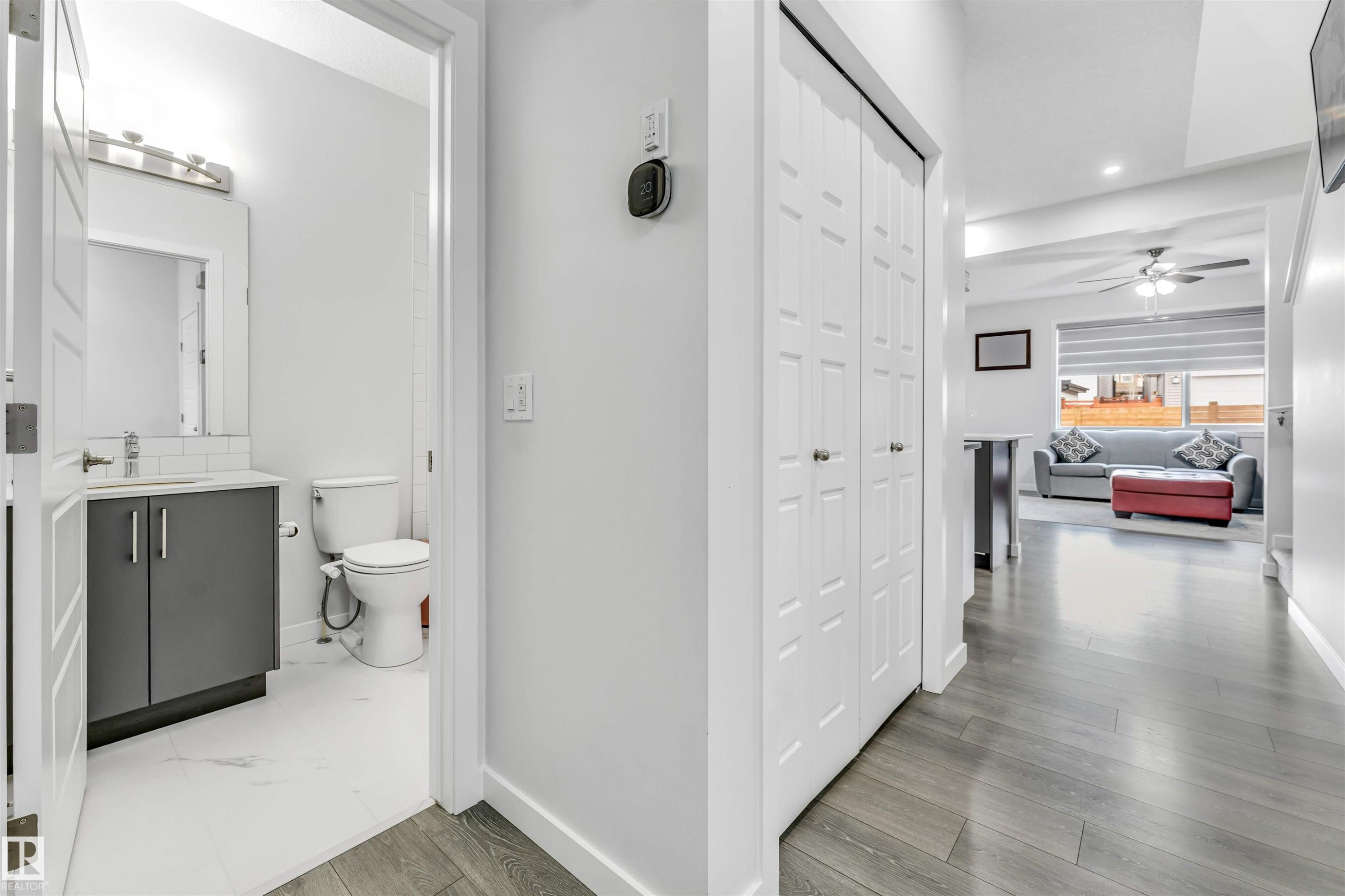 Powder room with a modern vanity, white subway tile backsplash, and a wall-mounted light fixture - 425 41 Street, Edmonton, AB - Indoor