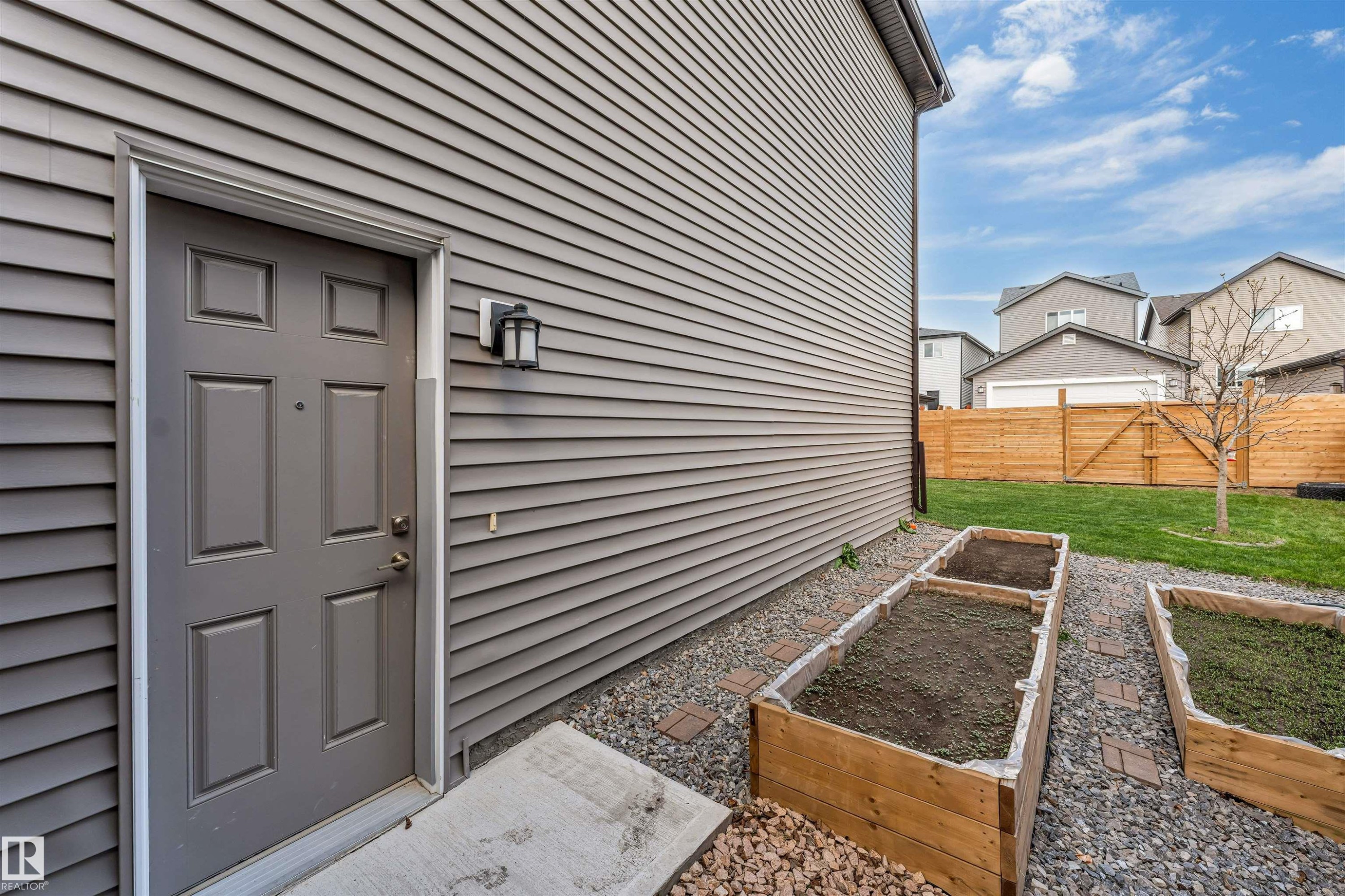 Exterior entry featuring a paneled door with an adjacent wall lantern - 425 41 Street, Edmonton, AB - Outdoor