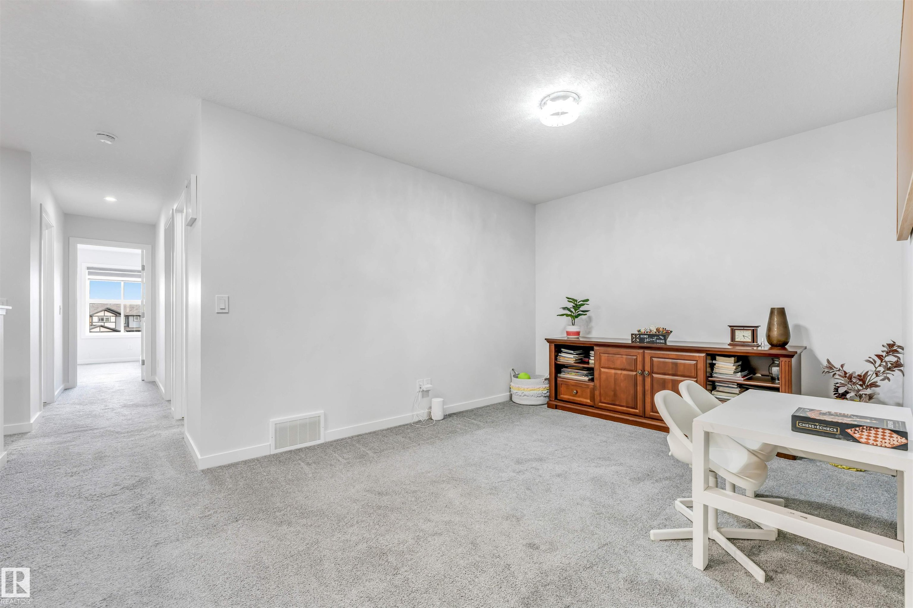 Carpeted room with white walls, ceiling-mounted light fixture, and white baseboards - 425 41 Street, Edmonton, AB - Indoor