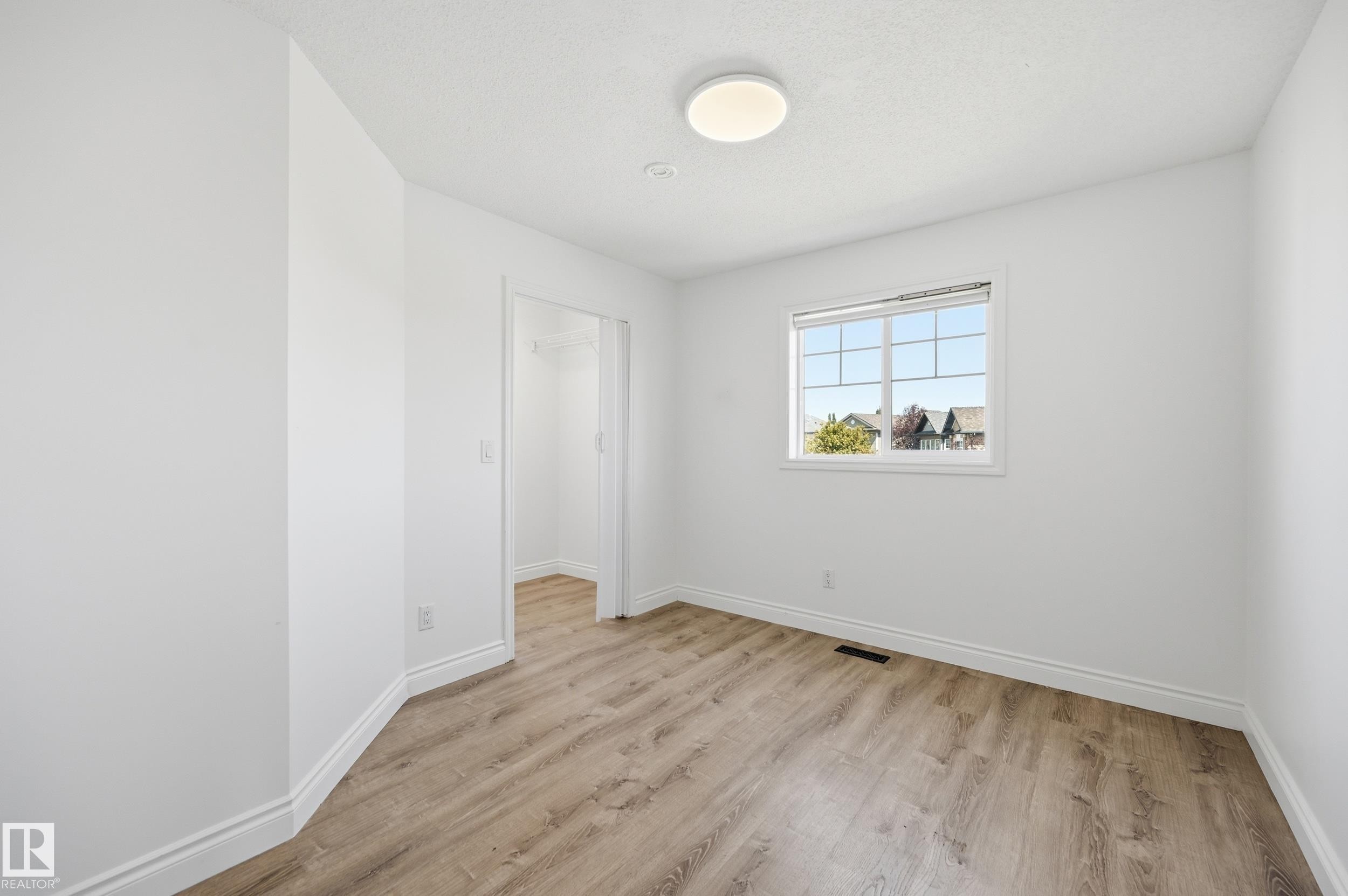 Room featuring wood-finish flooring, white walls, and a multi-pane window - 1 Southfork Close, Leduc, AB - Indoor Photo Showing Other Room