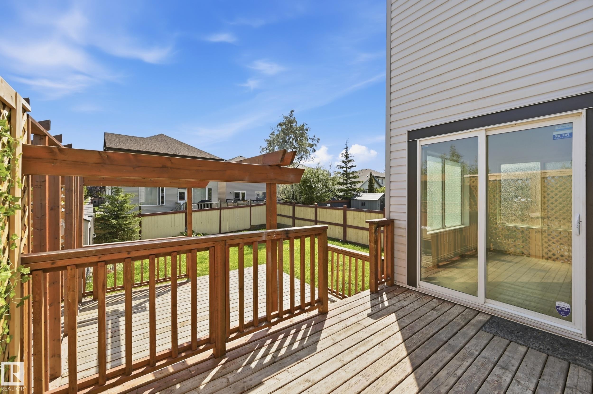 Wood deck featuring a pergola structure, wooden railings, and direct access to the interior via a sliding glass door - 1 Southfork Close, Leduc, AB - Outdoor With Deck Patio Veranda With Exterior