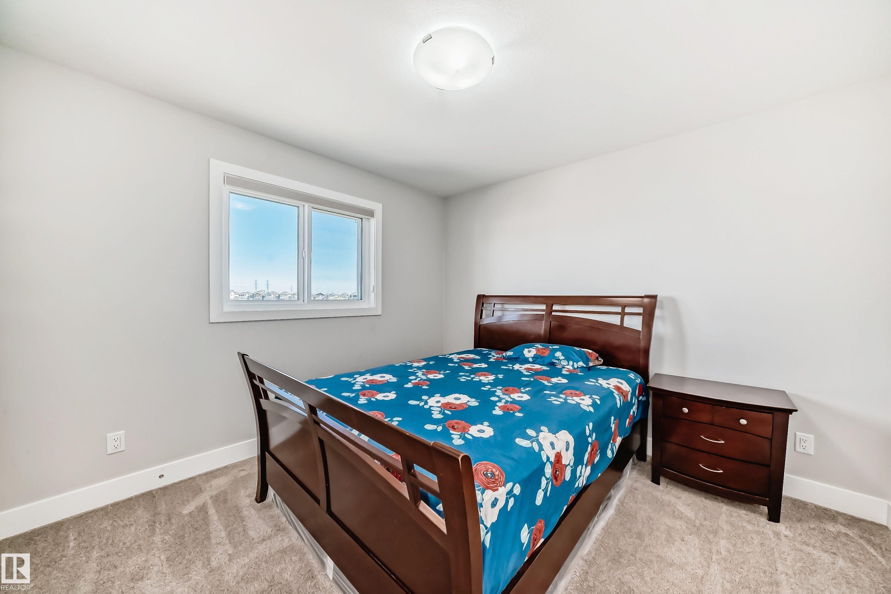 Carpeted bedroom with a single window and ceiling-mounted light fixture - 2464 15 Avenue Nw, Edmonton, AB - Indoor Photo Showing Bedroom