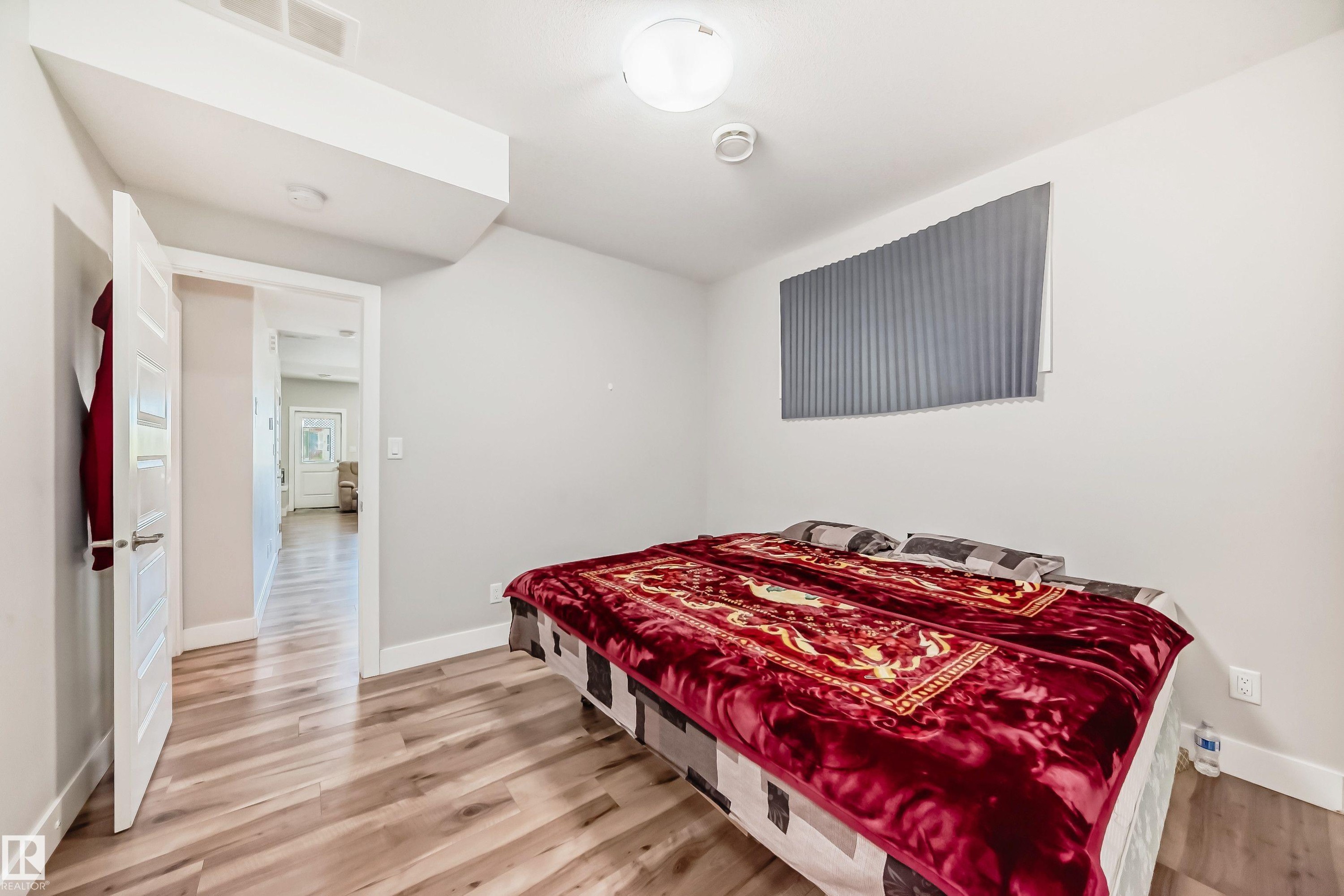 Room featuring light wood-finish flooring, white baseboards, and a neutral wall color - 2464 15 Avenue Nw, Edmonton, AB - Indoor Photo Showing Bedroom