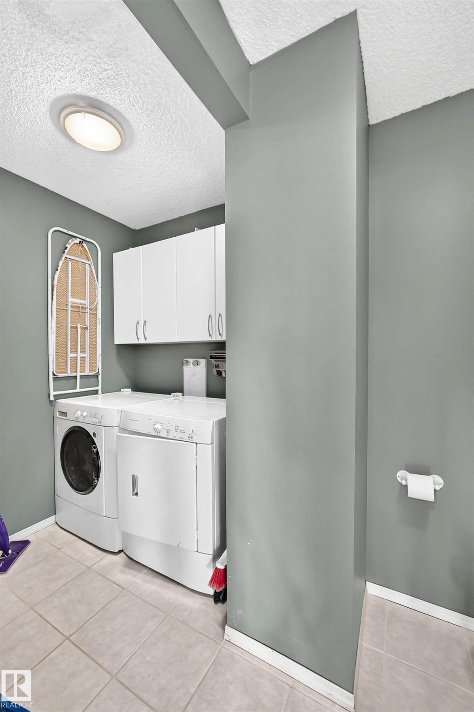 Dedicated laundry area with tile flooring and overhead white cabinetry - 1116 39 Street Nw, Edmonton, AB - Indoor Photo Showing Laundry Room