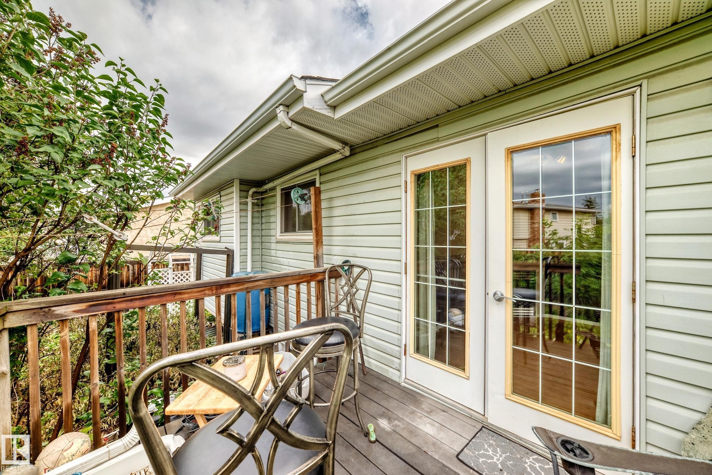 Deck with wood railing and flooring, featuring white French doors with divided lites - 1116 39 Street Nw, Edmonton, AB - Outdoor With Deck Patio Veranda With Exterior