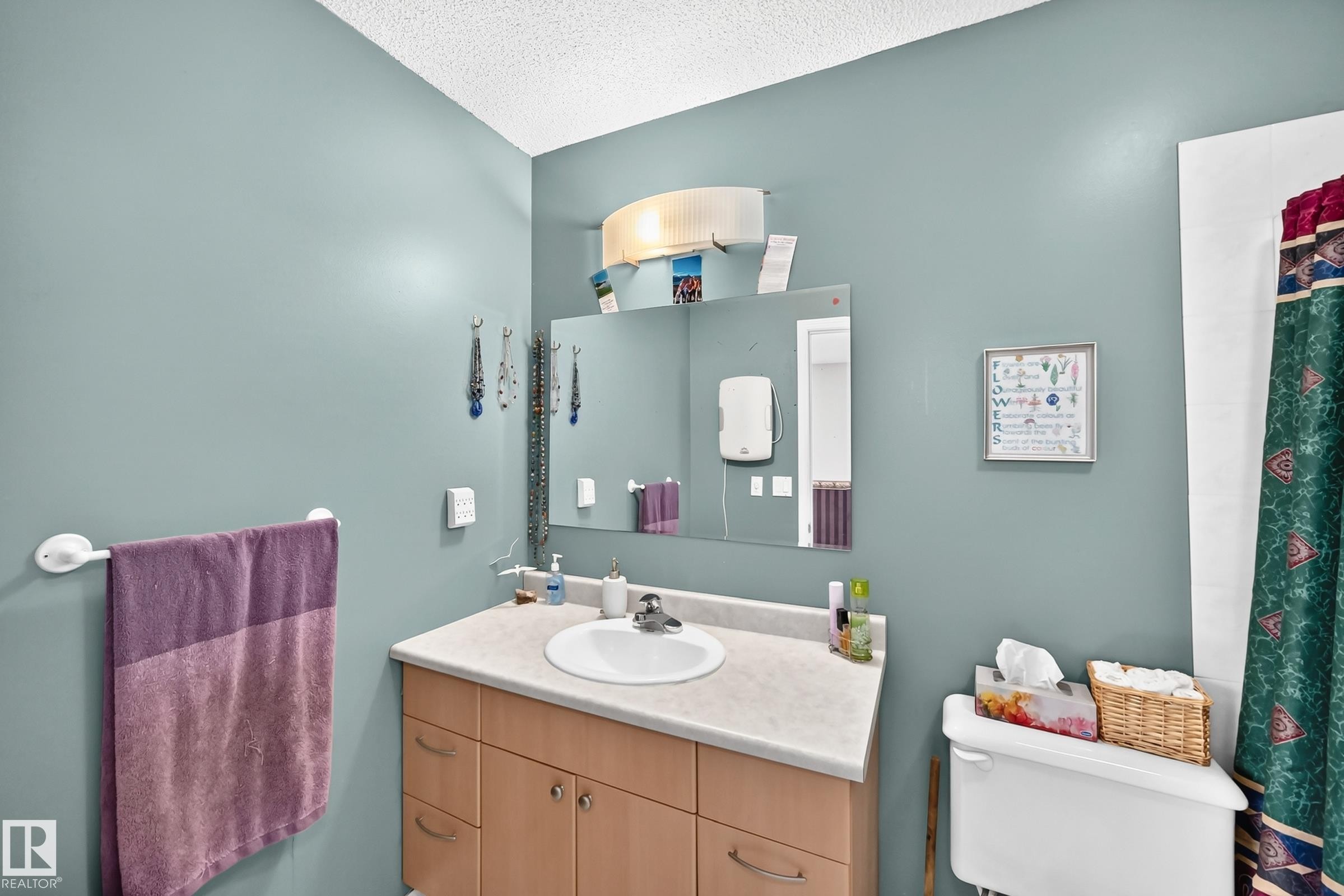 Bathroom featuring a single vanity with a light wood-finish cabinet and integrated white sink - 1116 39 Street Nw, Edmonton, AB - Indoor Photo Showing Bathroom
