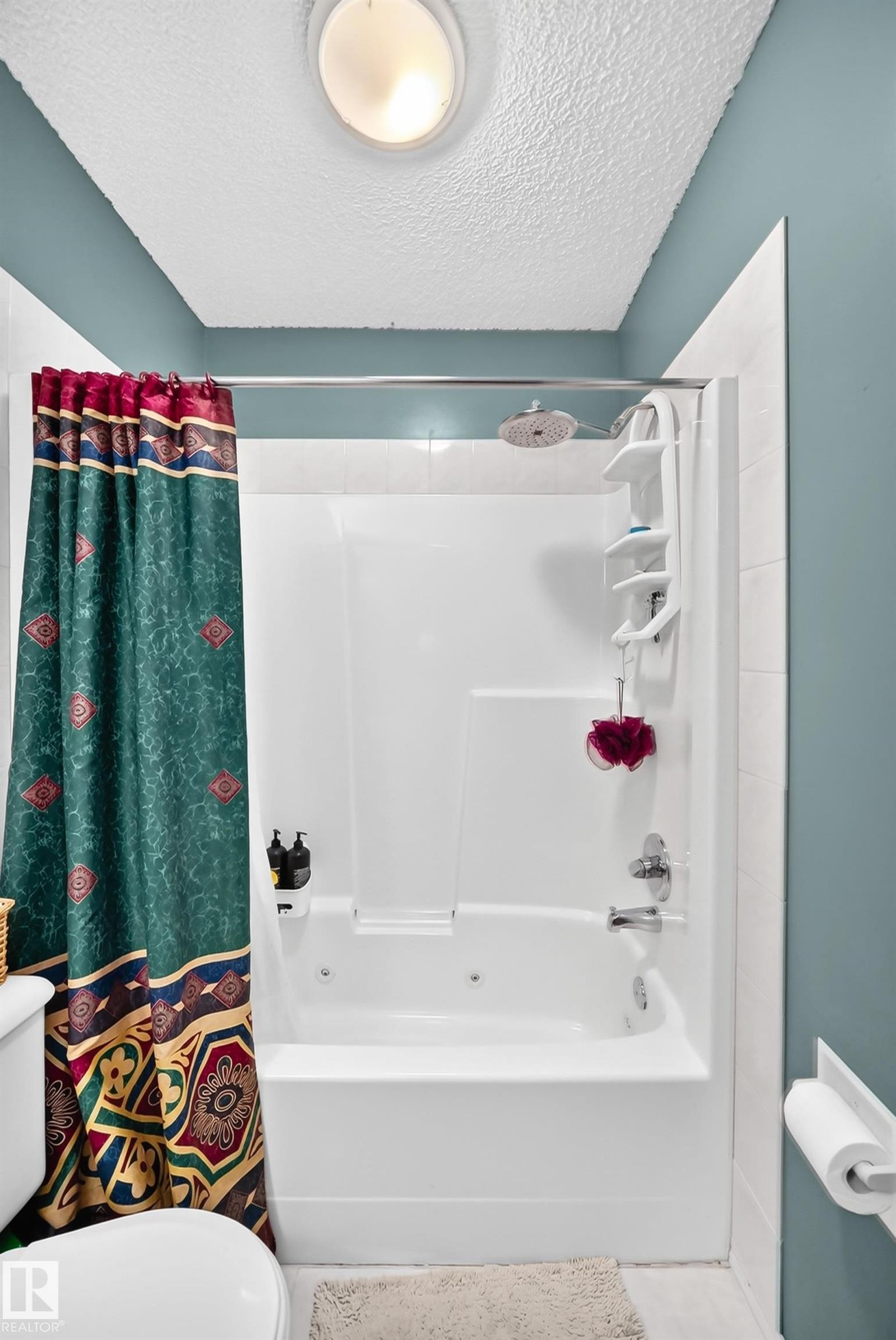 White bathtub with integrated wall surround, chrome fixtures, and a ceiling-mounted light fixture - 1116 39 Street Nw, Edmonton, AB - Indoor Photo Showing Bathroom