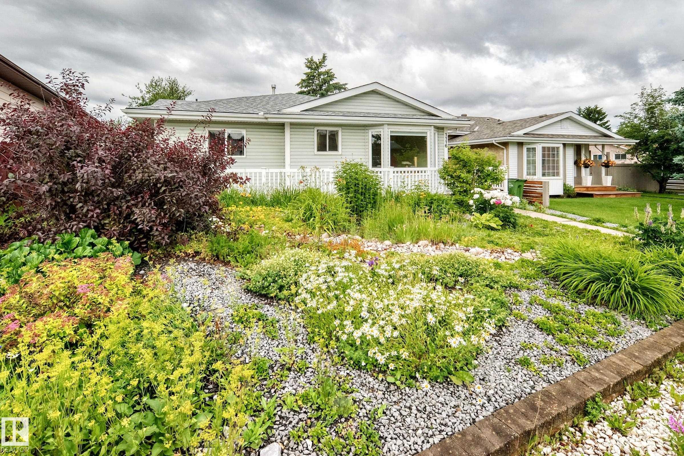 Front yard with a variety of plantings, decorative gravel, and a low retaining wall - 1116 39 Street Nw, Edmonton, AB - Outdoor