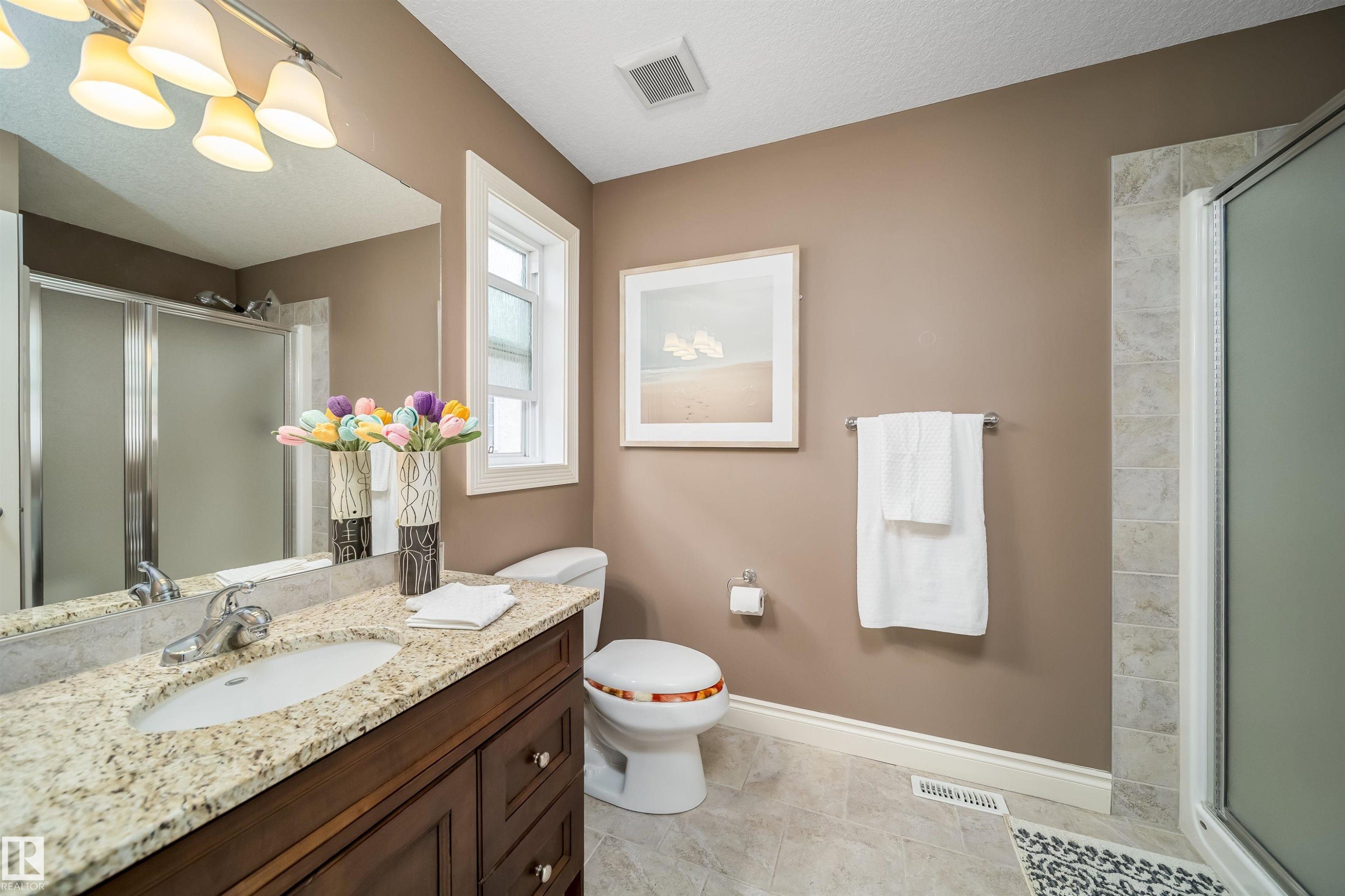 Bathroom featuring a vanity with an oval undermount sink, a granite countertop, and a dark wood-finish cabinet - 11342 79 Avenue, Edmonton, AB - Indoor Photo Showing Bathroom
