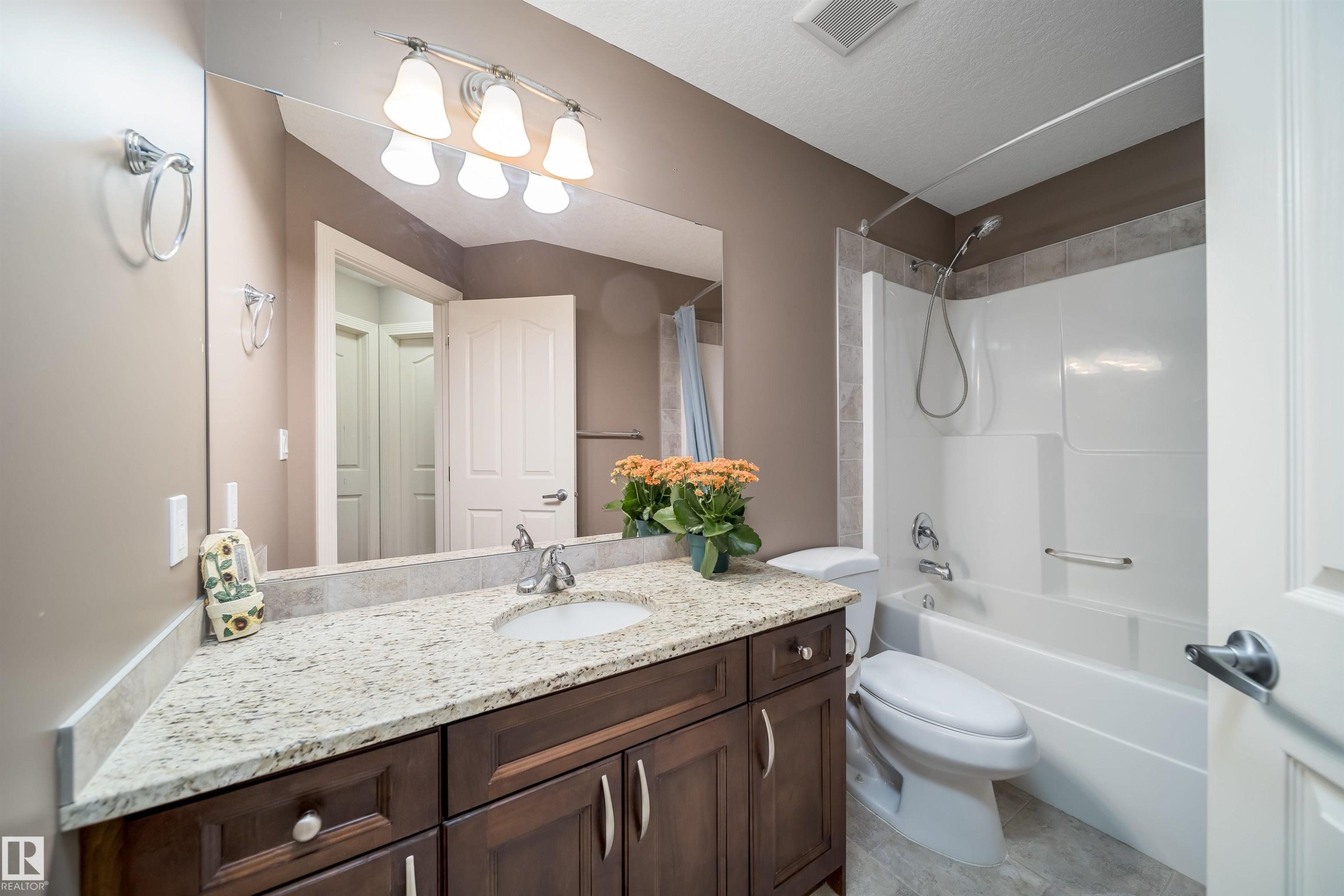 Bathroom featuring a dark wood-finish vanity with a granite countertop and an undermount sink - 11342 79 Avenue, Edmonton, AB - Indoor Photo Showing Bathroom