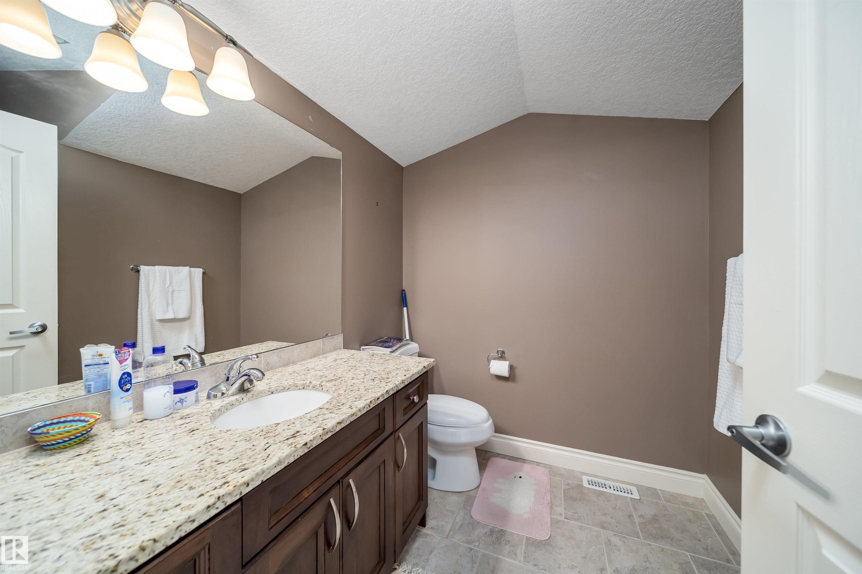 Bathroom featuring a single vanity with a light-toned countertop, an integrated sink, and a chrome faucet - 11342 79 Avenue, Edmonton, AB - Indoor Photo Showing Bathroom