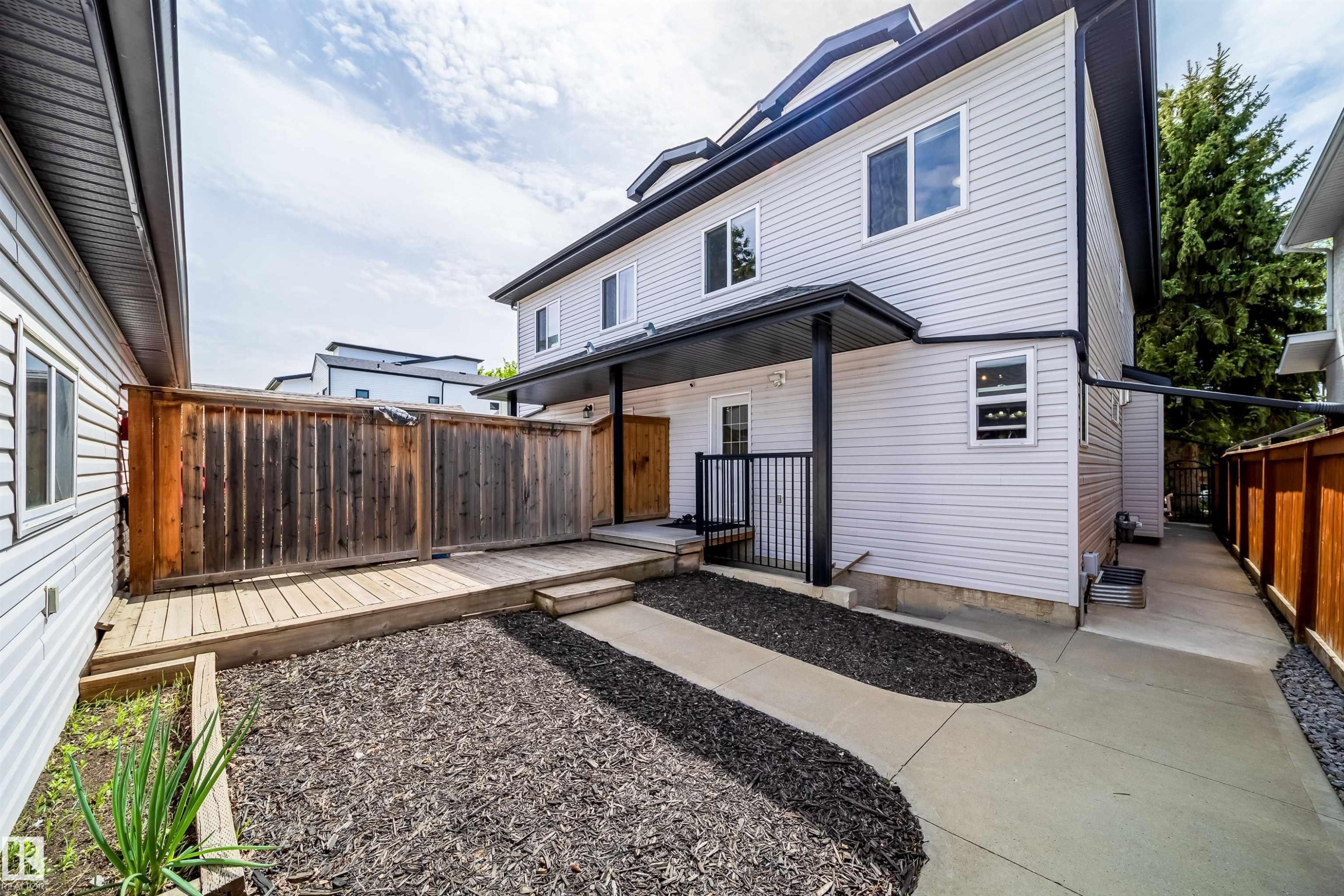 Exterior featuring light-colored siding, black trim, and a covered entryway - 11342 79 Avenue, Edmonton, AB - Outdoor With Exterior