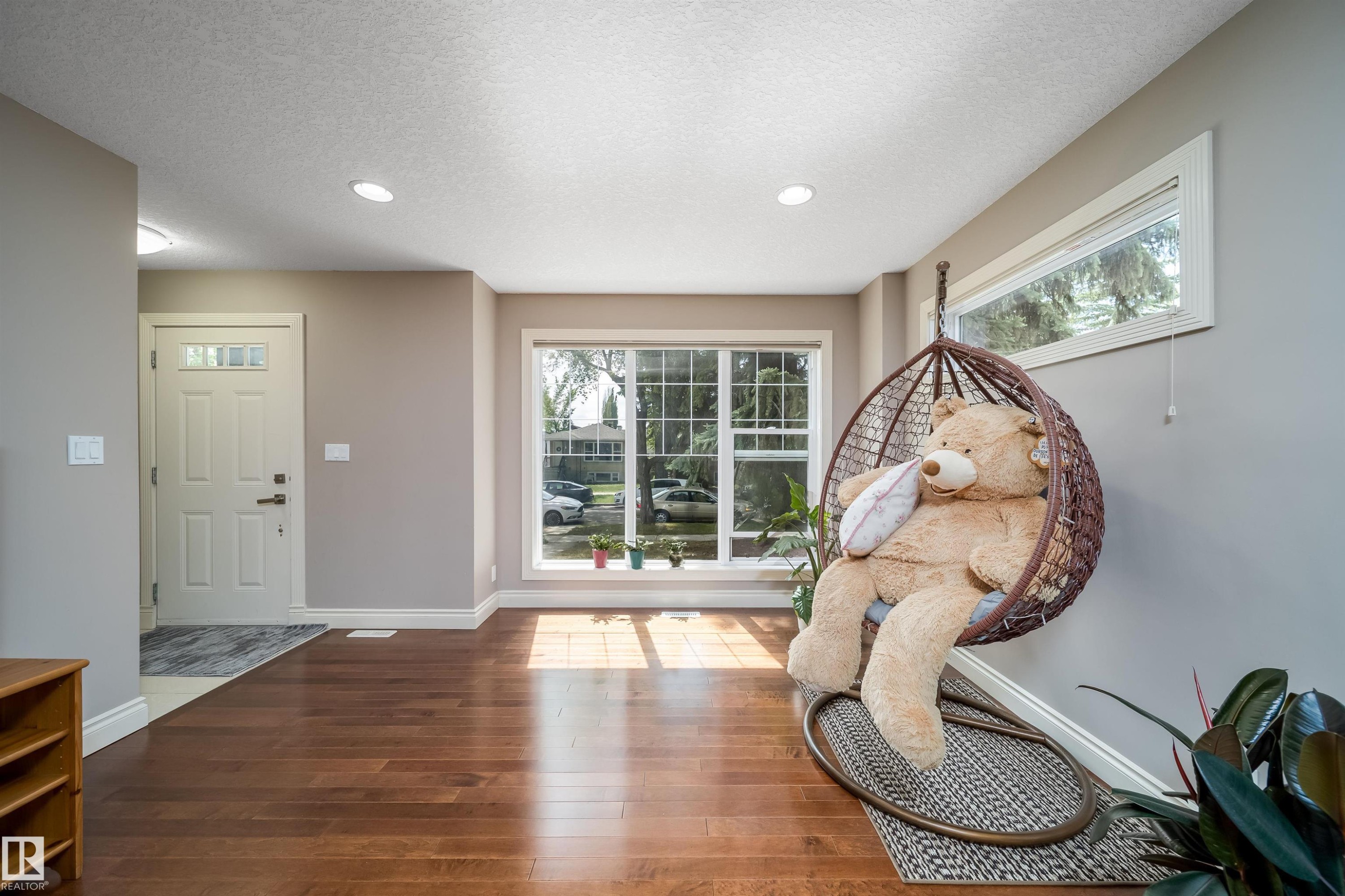 Entryway featuring a paneled door with glass inserts, recessed lighting, and wood-finish flooring extending into the main living area - 11342 79 Avenue, Edmonton, AB - Indoor Photo Showing Other Room