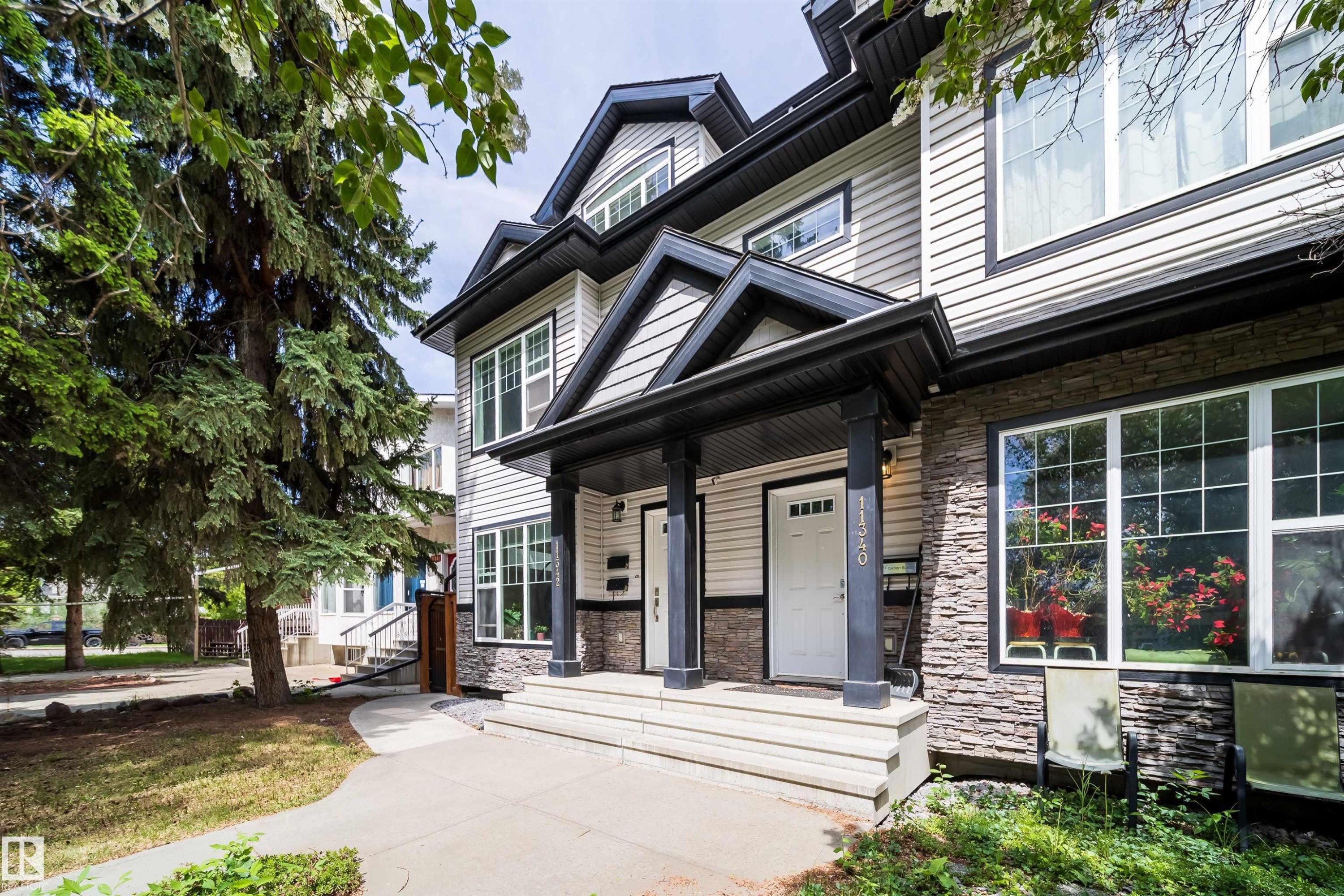 Multi-level facade featuring light siding and stone veneer accents - 11342 79 Avenue, Edmonton, AB - Outdoor With Facade