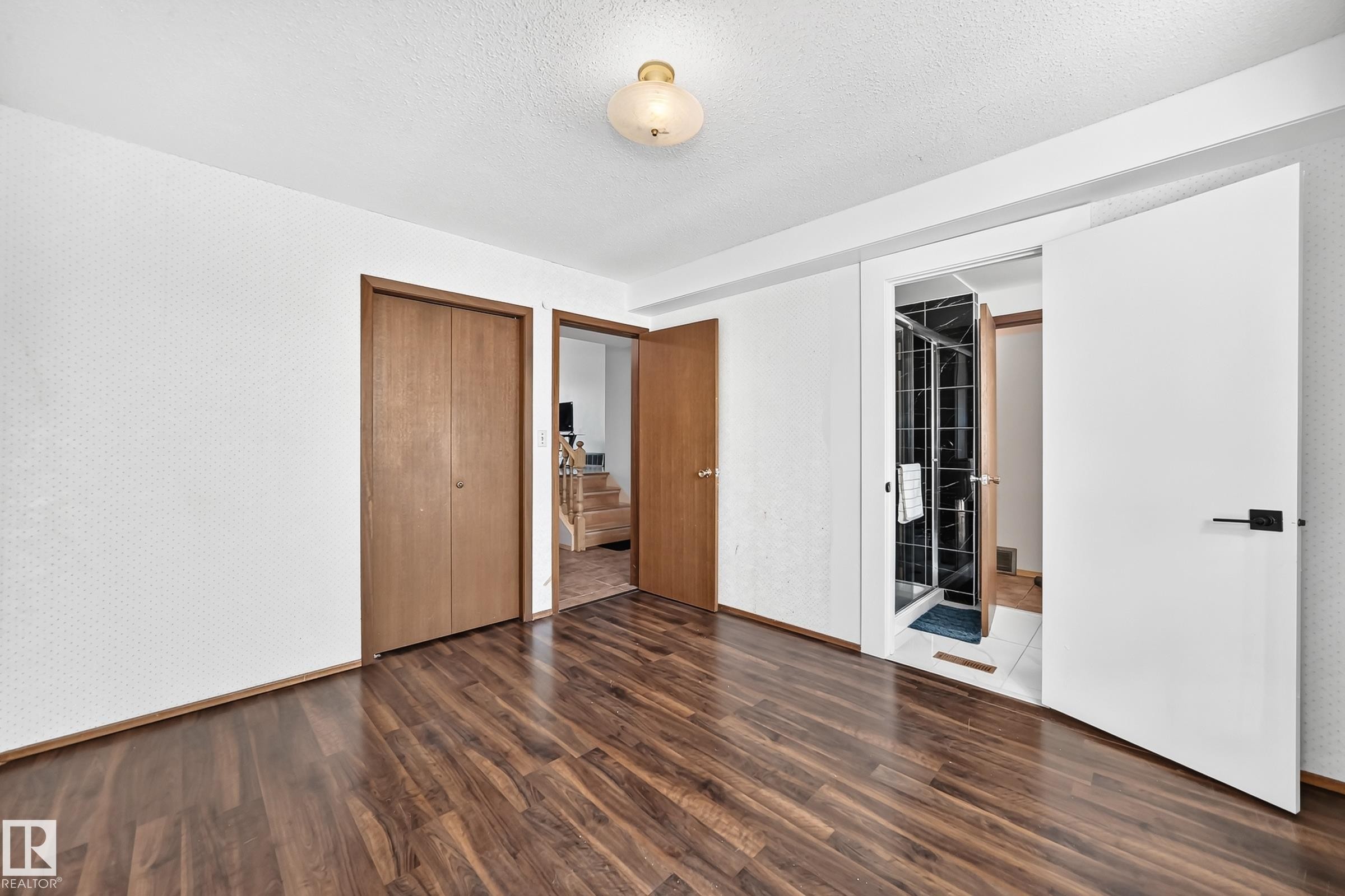 Room featuring wood-finish flooring, white walls, and a ceiling light fixture - 1928 68 Street Nw, Edmonton, AB - Indoor Photo Showing Other Room
