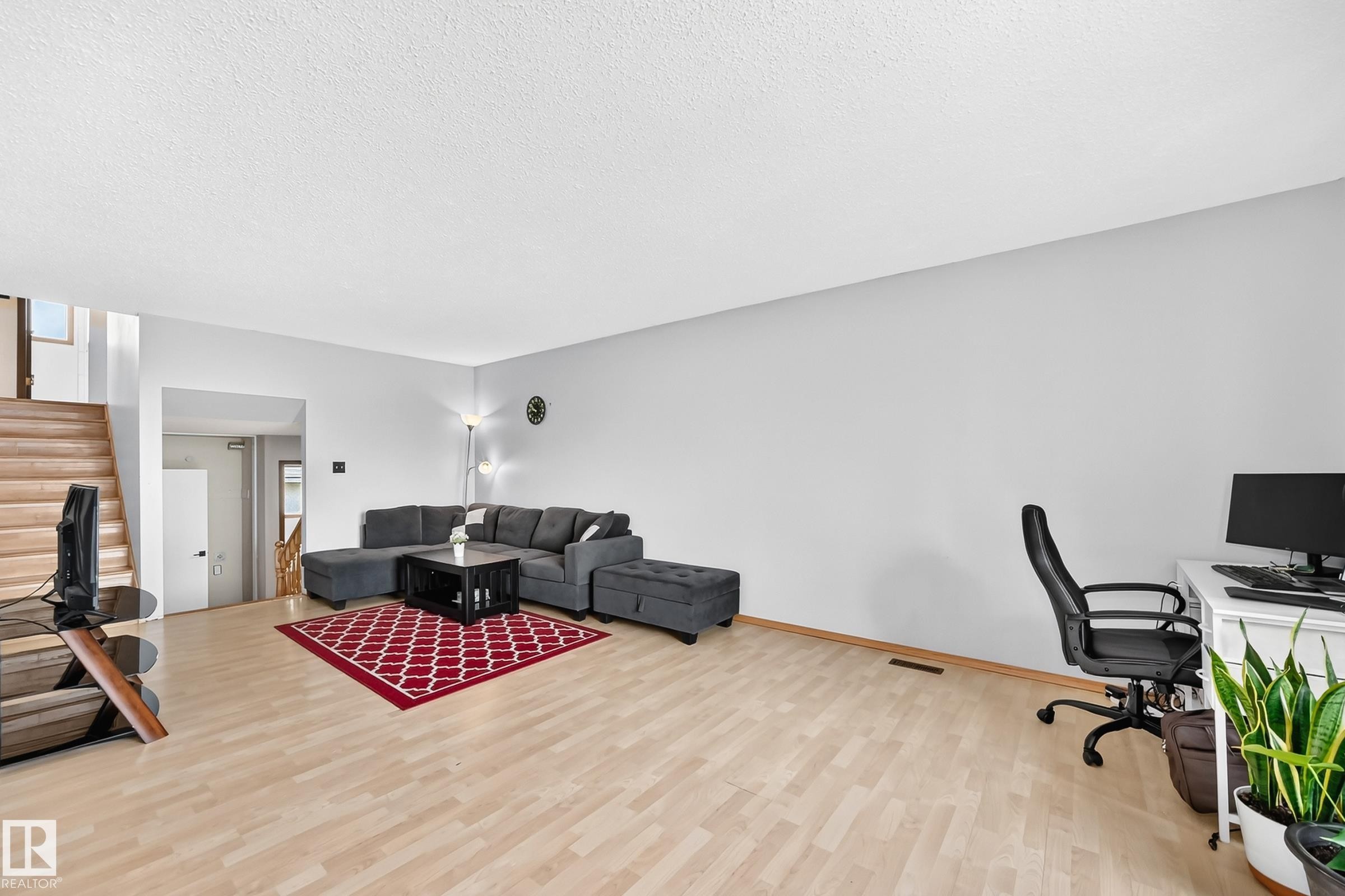 Open-concept living area featuring light wood-finish flooring and a neutral wall color - 1928 68 Street Nw, Edmonton, AB - Indoor Photo Showing Office