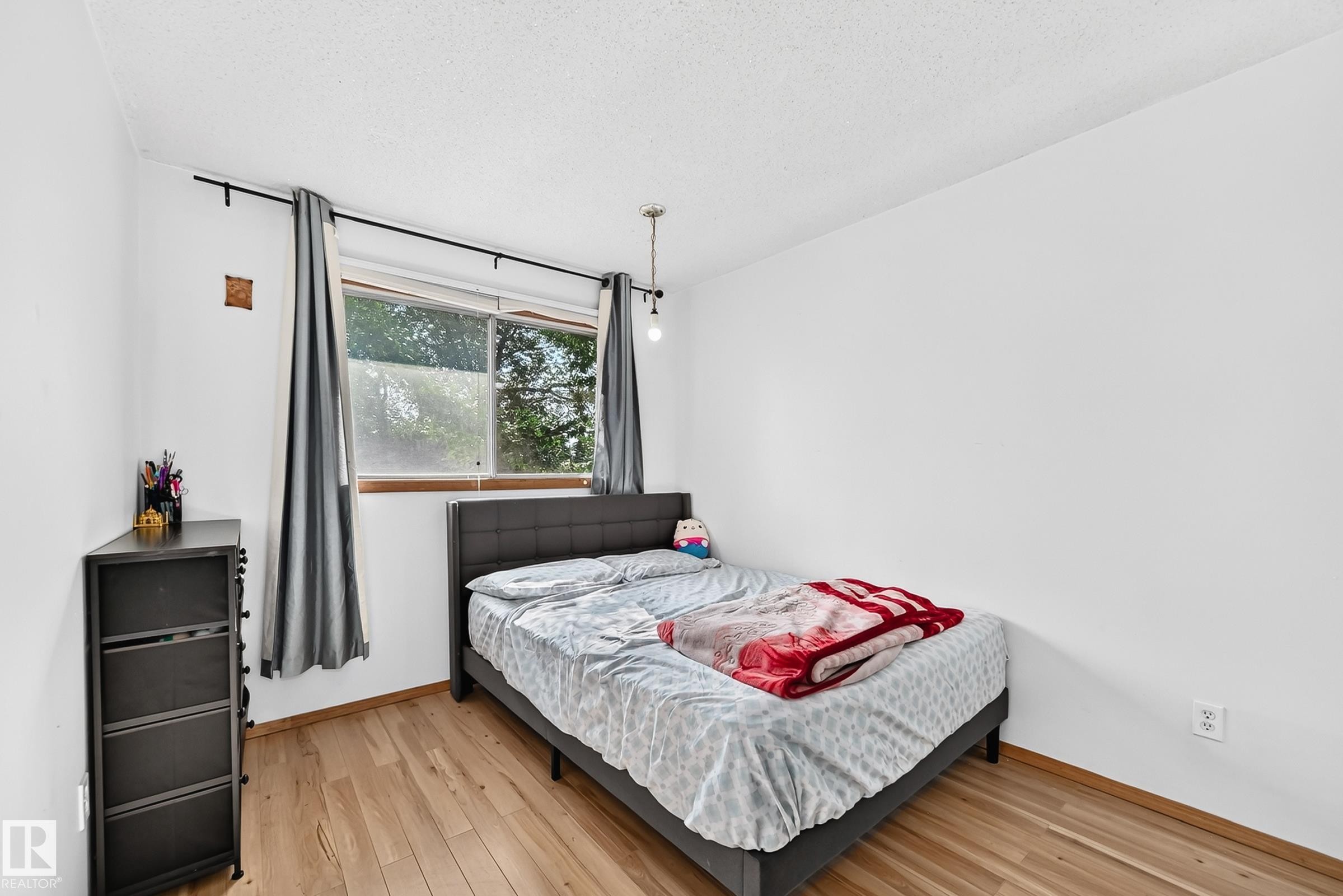 Hardwood-finish flooring complementing white walls - 1928 68 Street Nw, Edmonton, AB - Indoor Photo Showing Bedroom