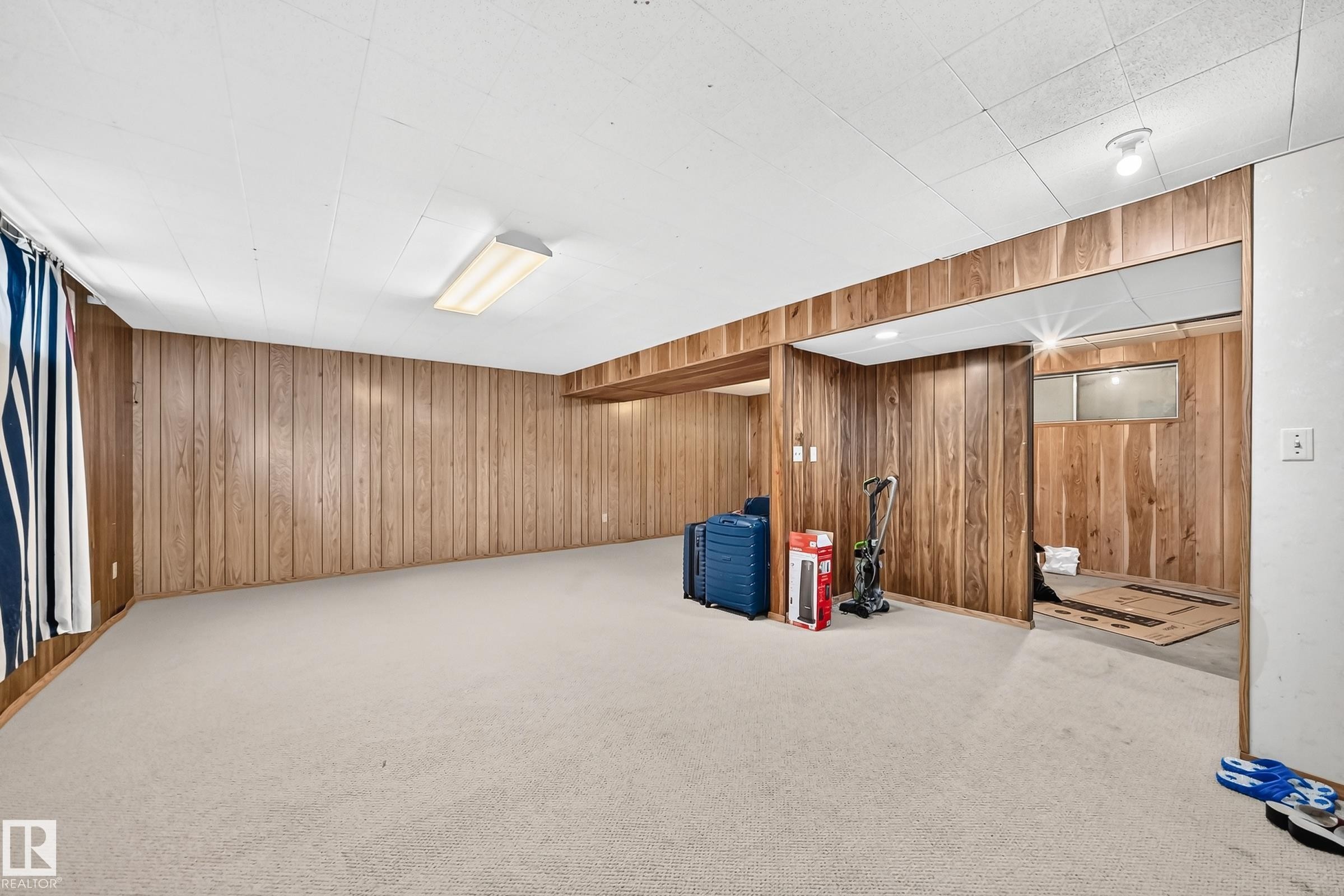 Finished basement space featuring paneling walls, recessed lighting, and a neutral carpeted floor - 1928 68 Street Nw, Edmonton, AB - Indoor