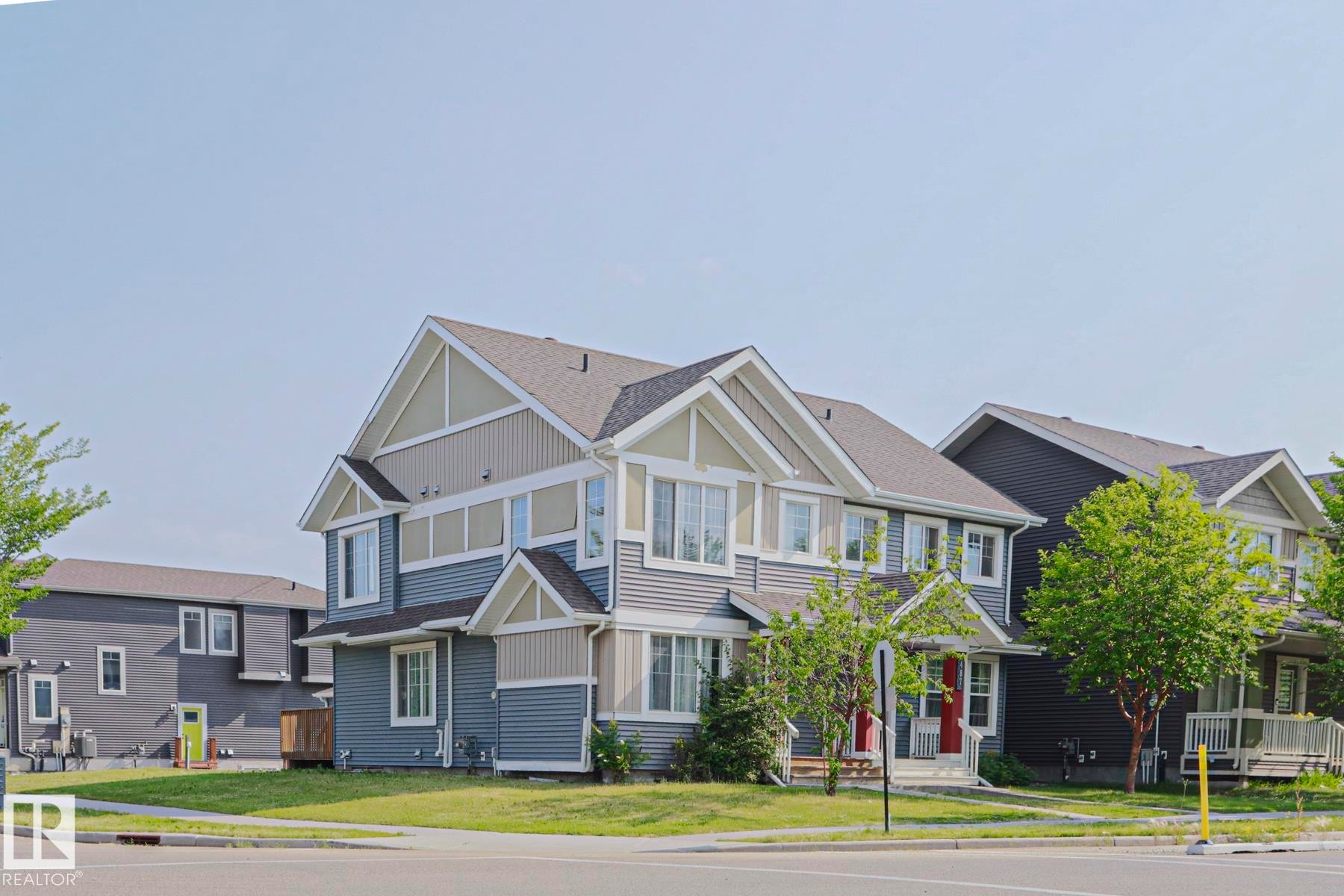 Two-story residence featuring multi-tone siding, prominent gables, and a mature front yard - 489 Orchards Boulevard Sw, Edmonton, AB - Outdoor With Facade