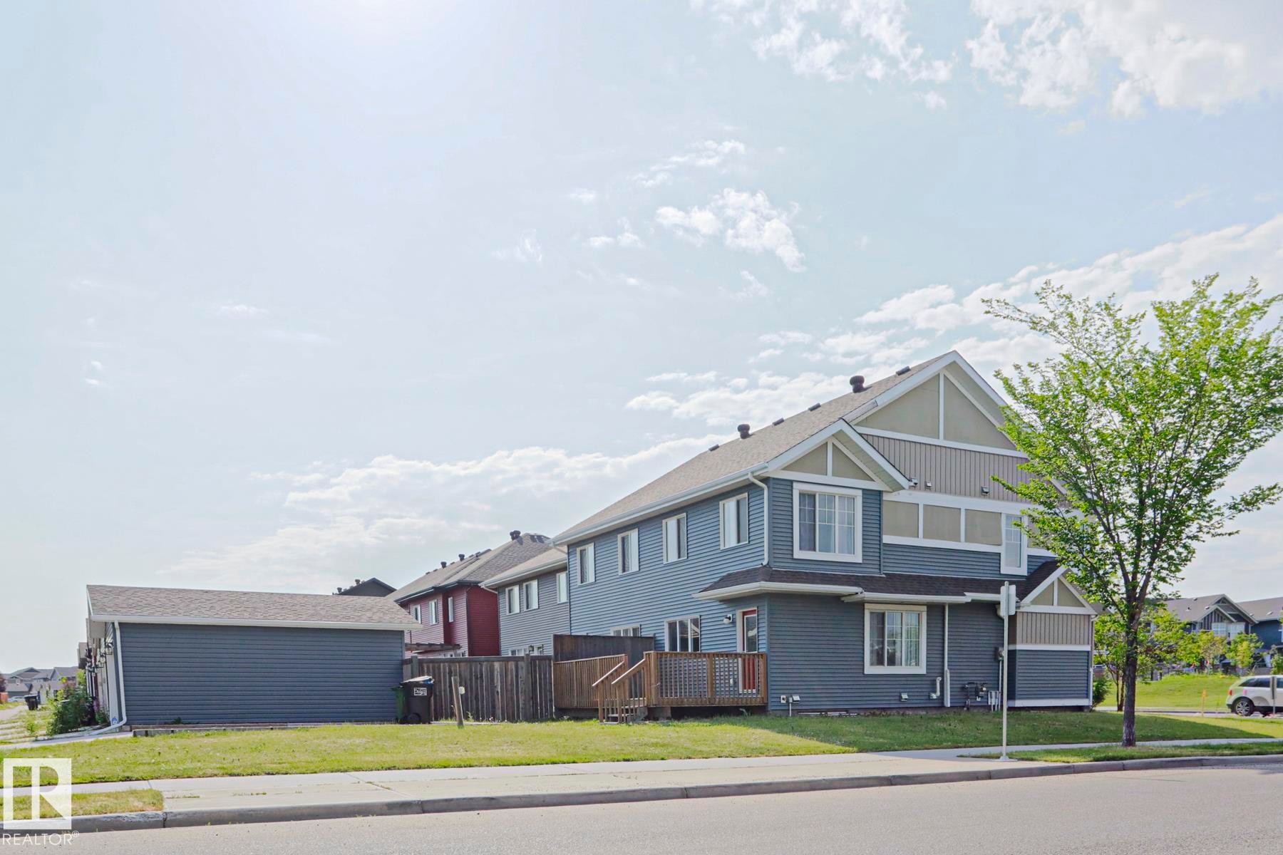 Two-story residence featuring blue siding with light beige and white accents - 489 Orchards Boulevard Sw, Edmonton, AB - Outdoor
