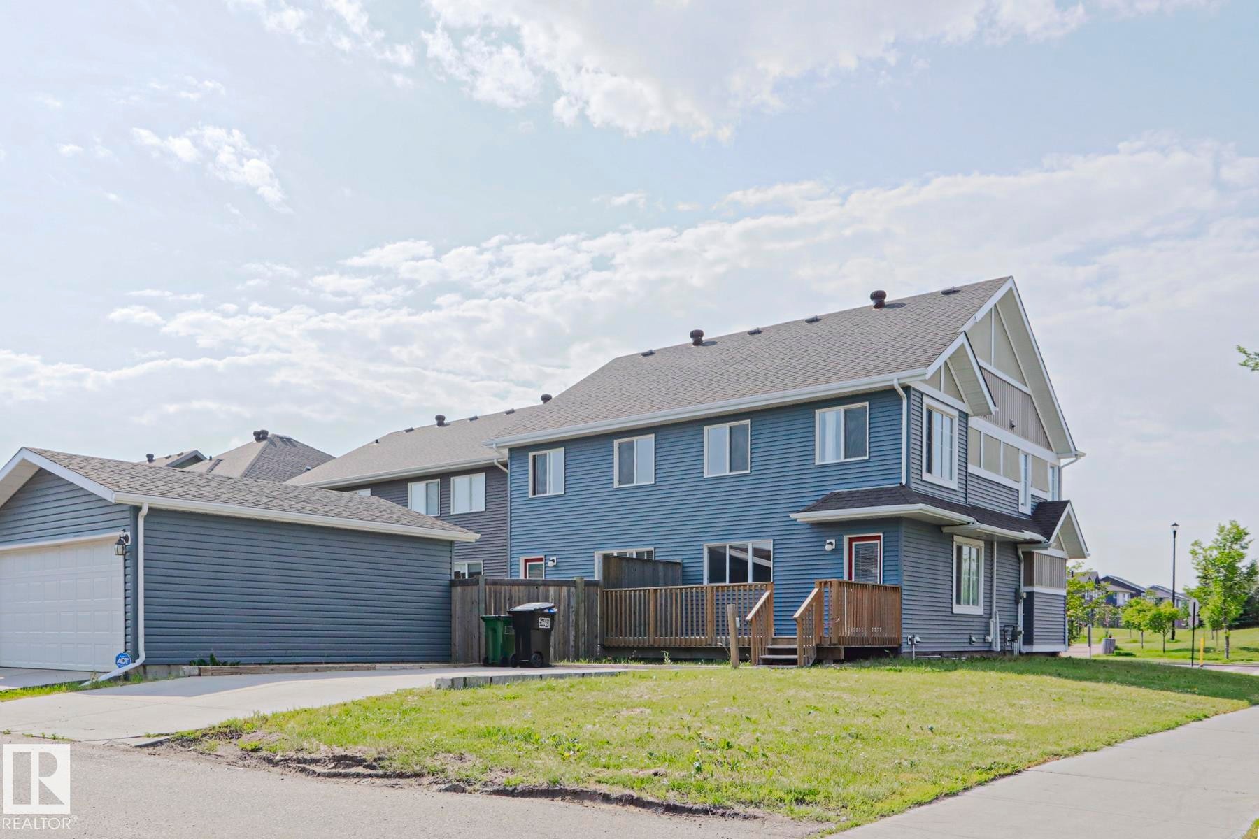 Exterior featuring blue horizontal siding and a dark shingle roof - 489 Orchards Boulevard Sw, Edmonton, AB - Outdoor